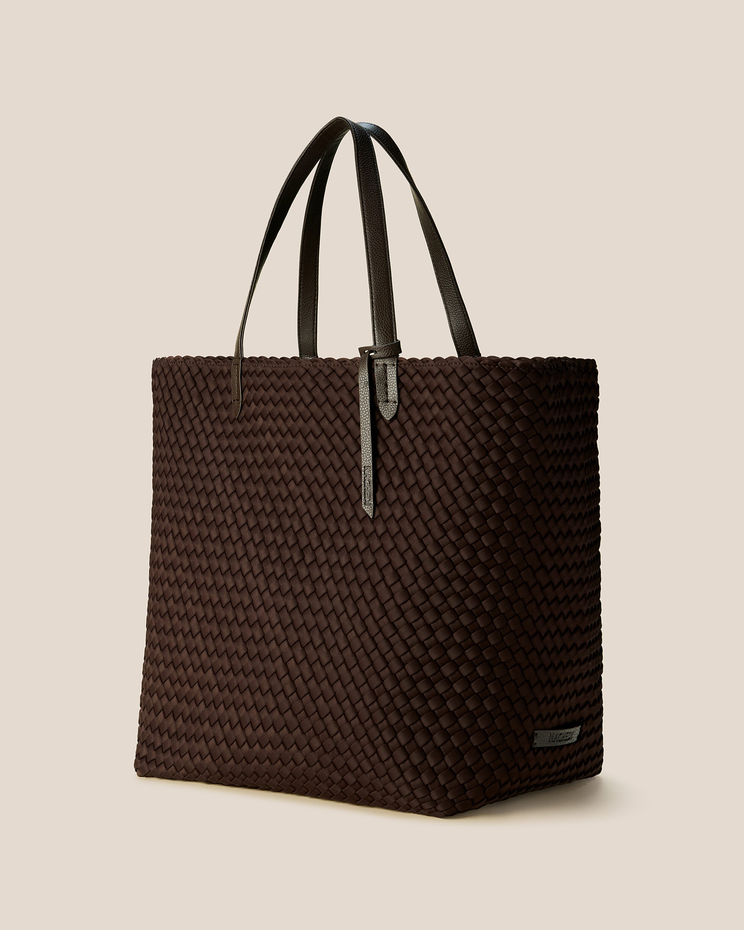 Jetsetter Tote in Chocolate shown from a side angle, highlighting its handwoven neoprene construction and top zip closure.