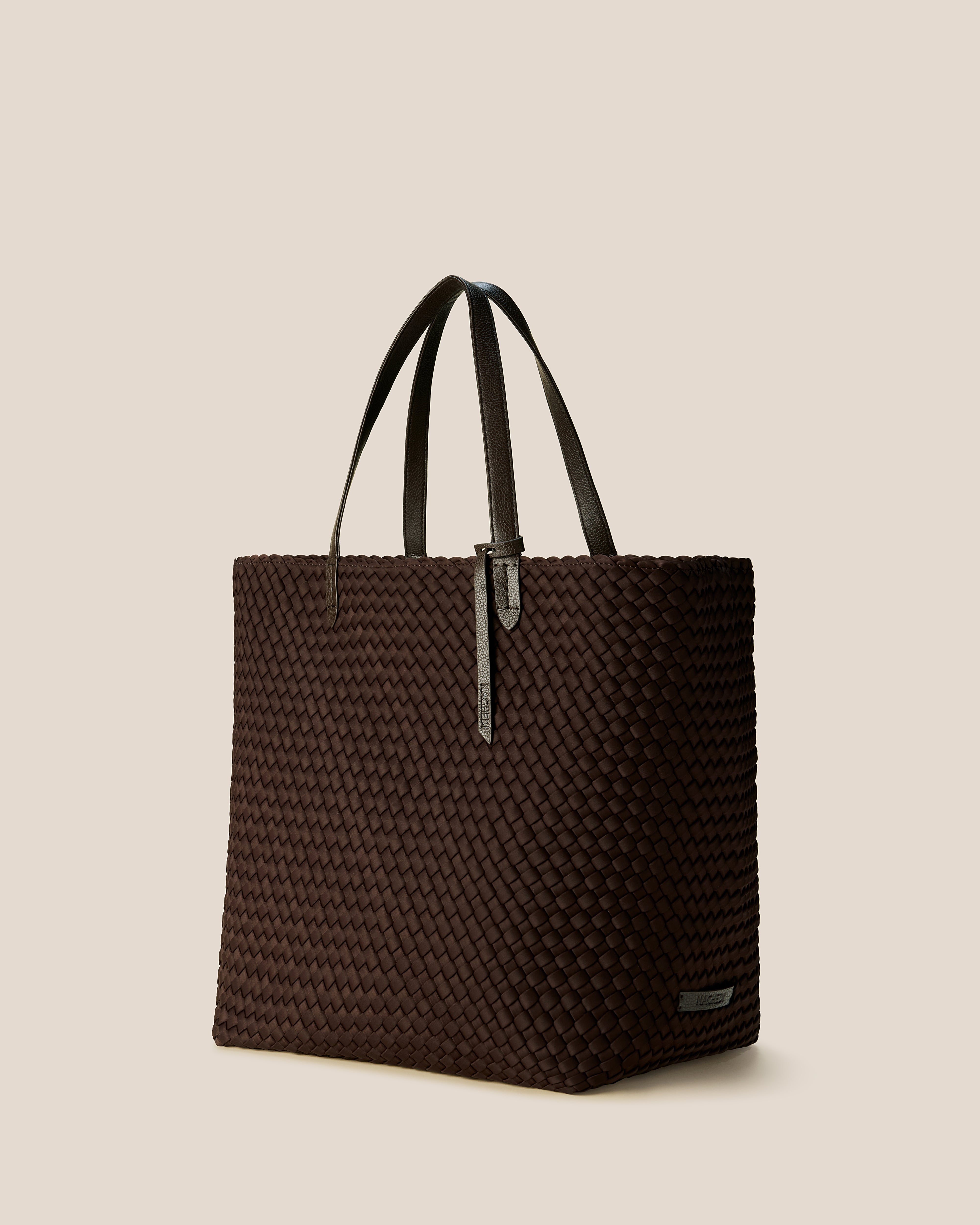 Jetsetter Tote in Chocolate shown from a side angle, highlighting its handwoven neoprene construction and top zip closure.
