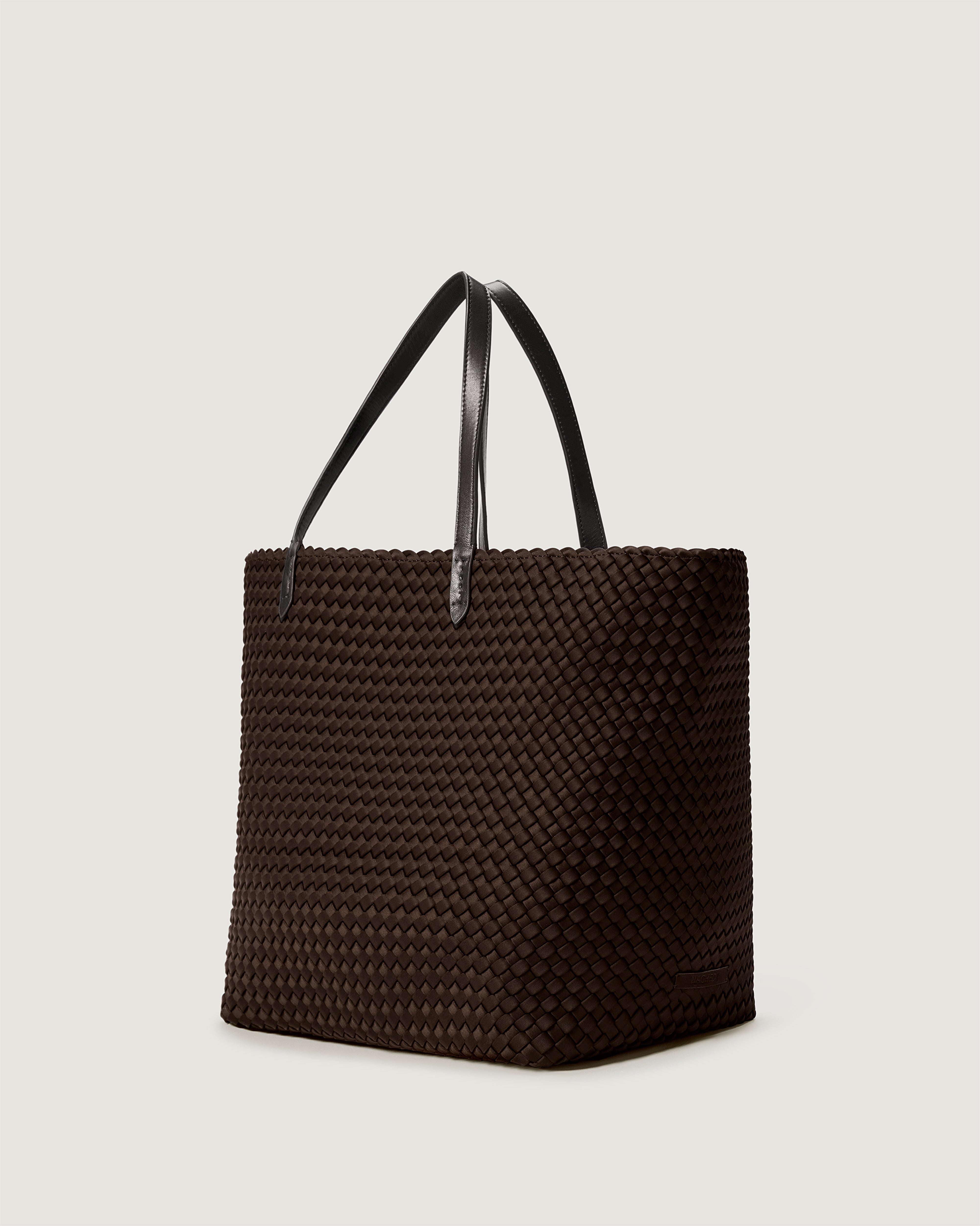 Jetsetter Tote in Chocolate shown from a side angle, highlighting its handwoven neoprene construction and top zip closure.