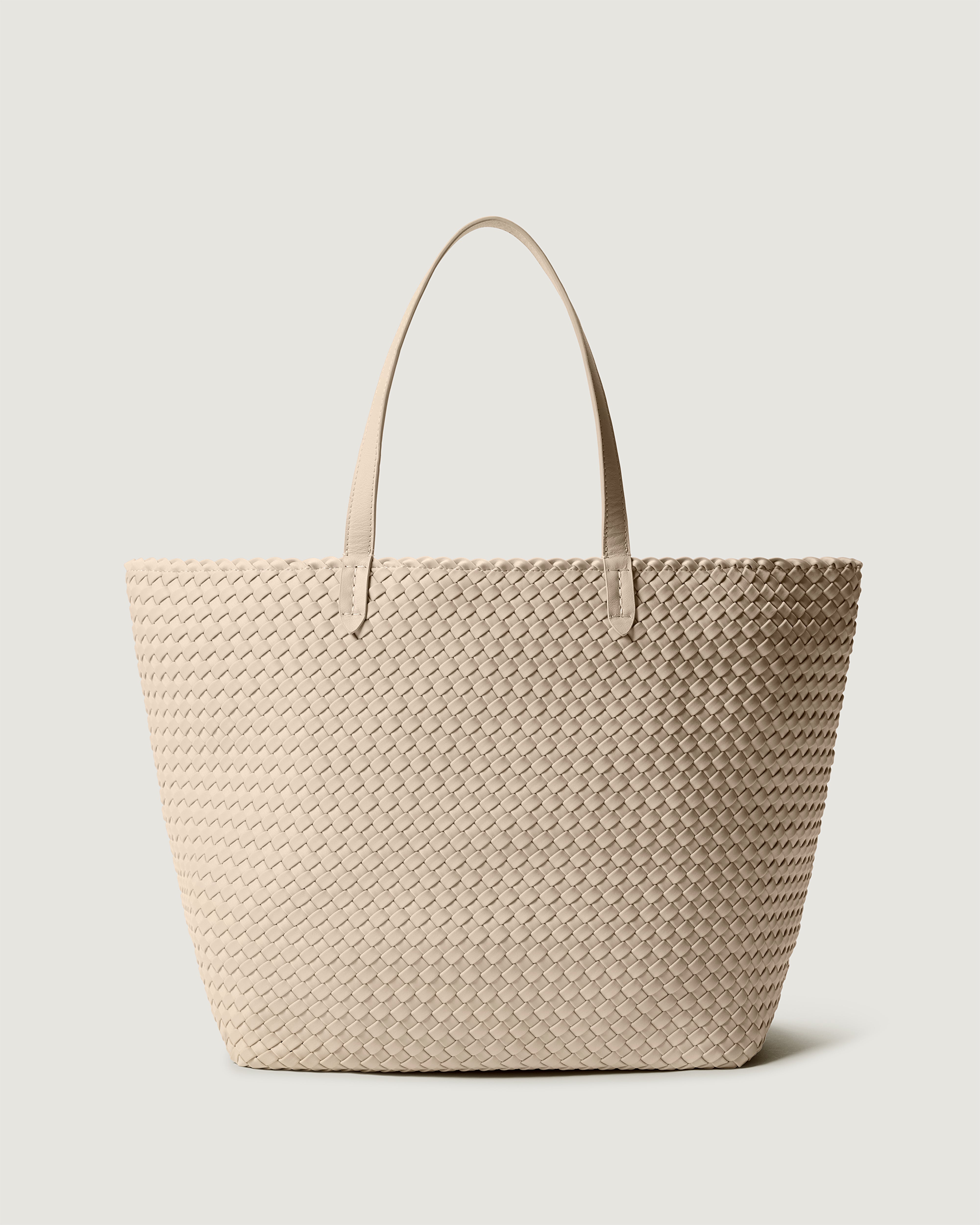 Jetsetter Tote in Ecru, a cream tone, in handwoven neoprene, featuring a top zip closure, and leather handles.