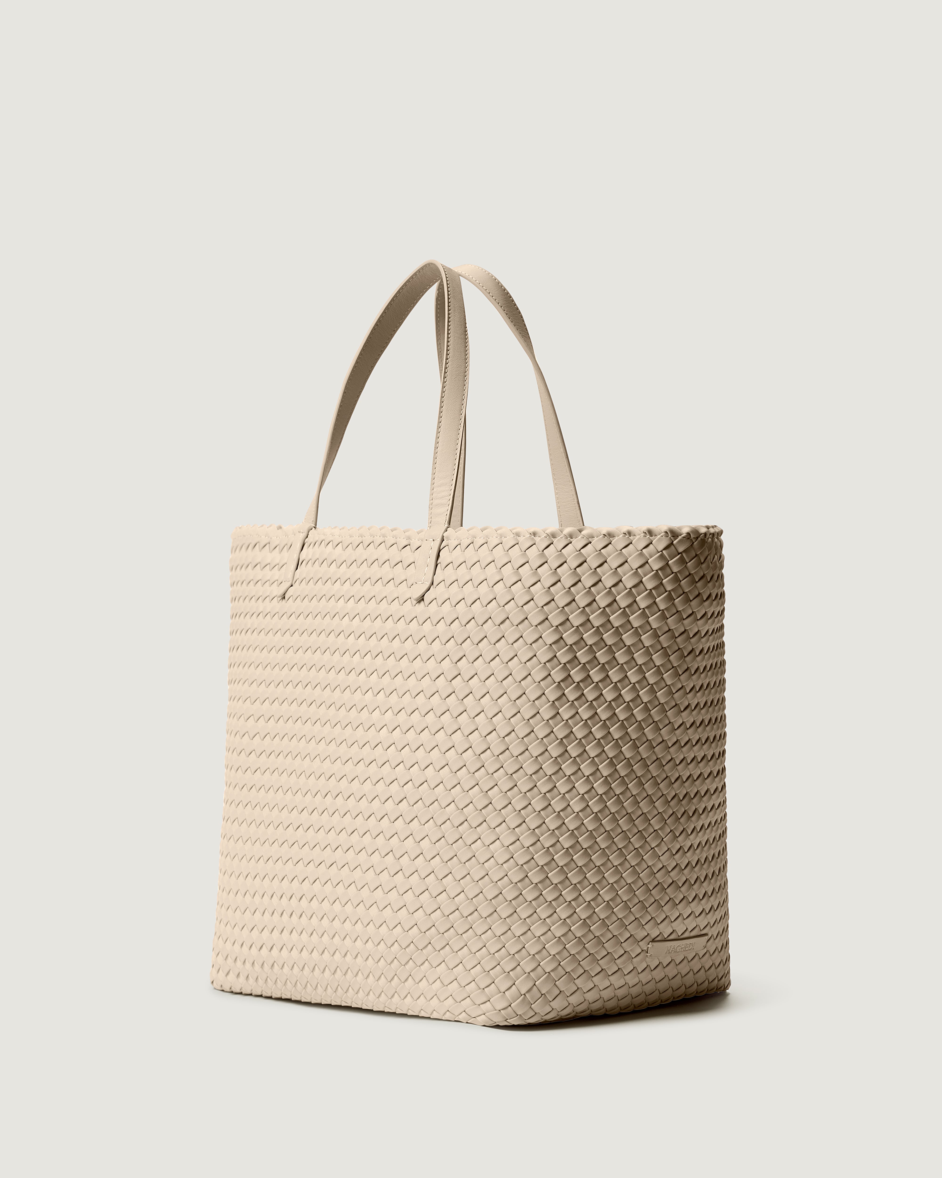 Jetsetter Tote in Ecru shown from a side angle, highlighting its handwoven neoprene construction and top zip closure.