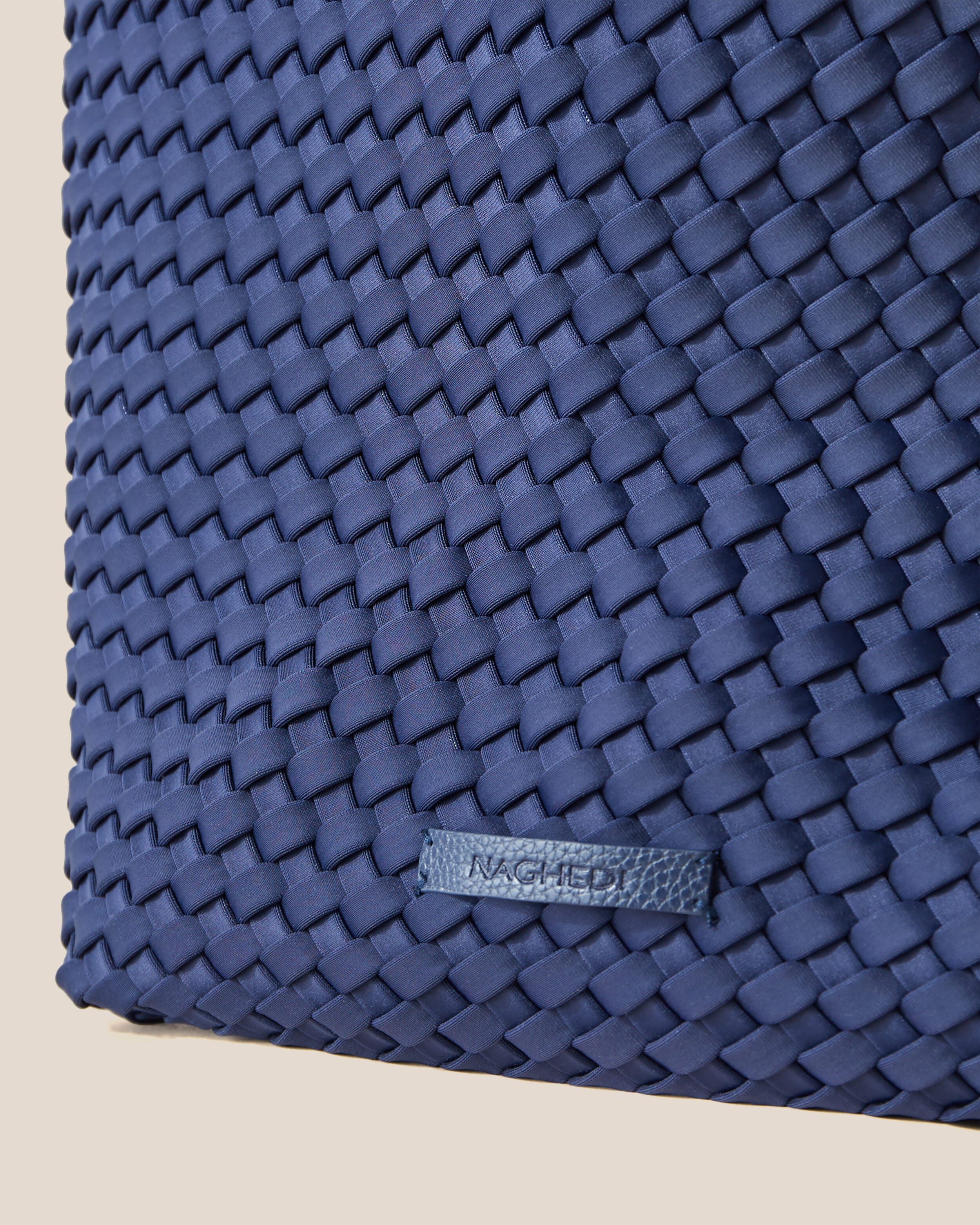 Close-up of stamped NAGHEDI logo on Jetsetter Tote in Ink Blue.