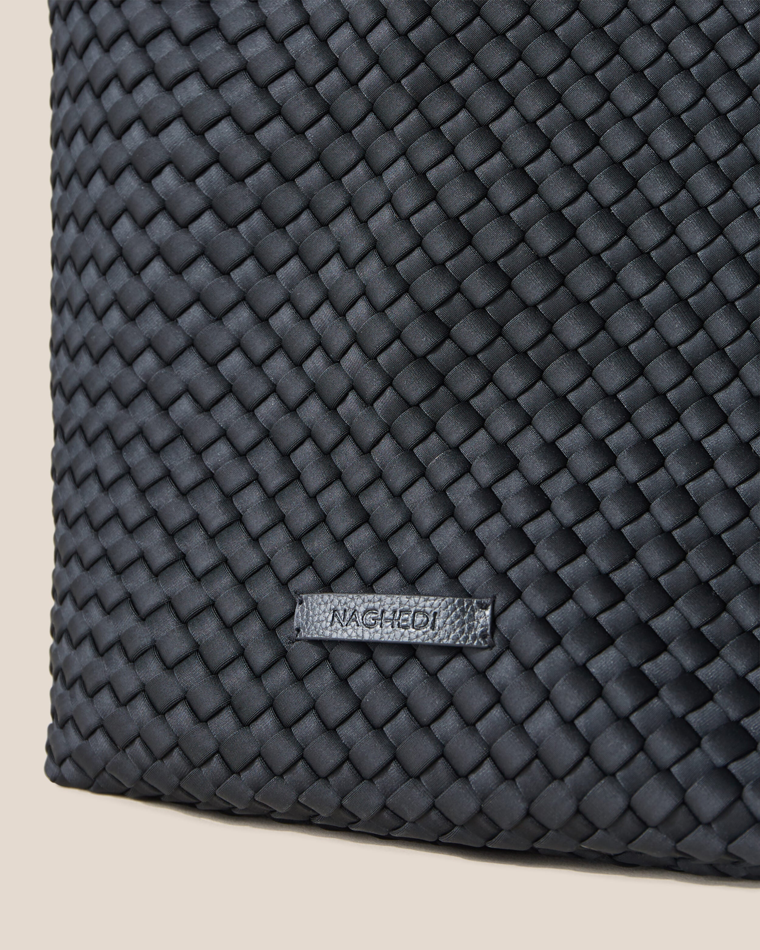 Close-up of stamped NAGHEDI logo on Jetsetter Tote in Onyx.