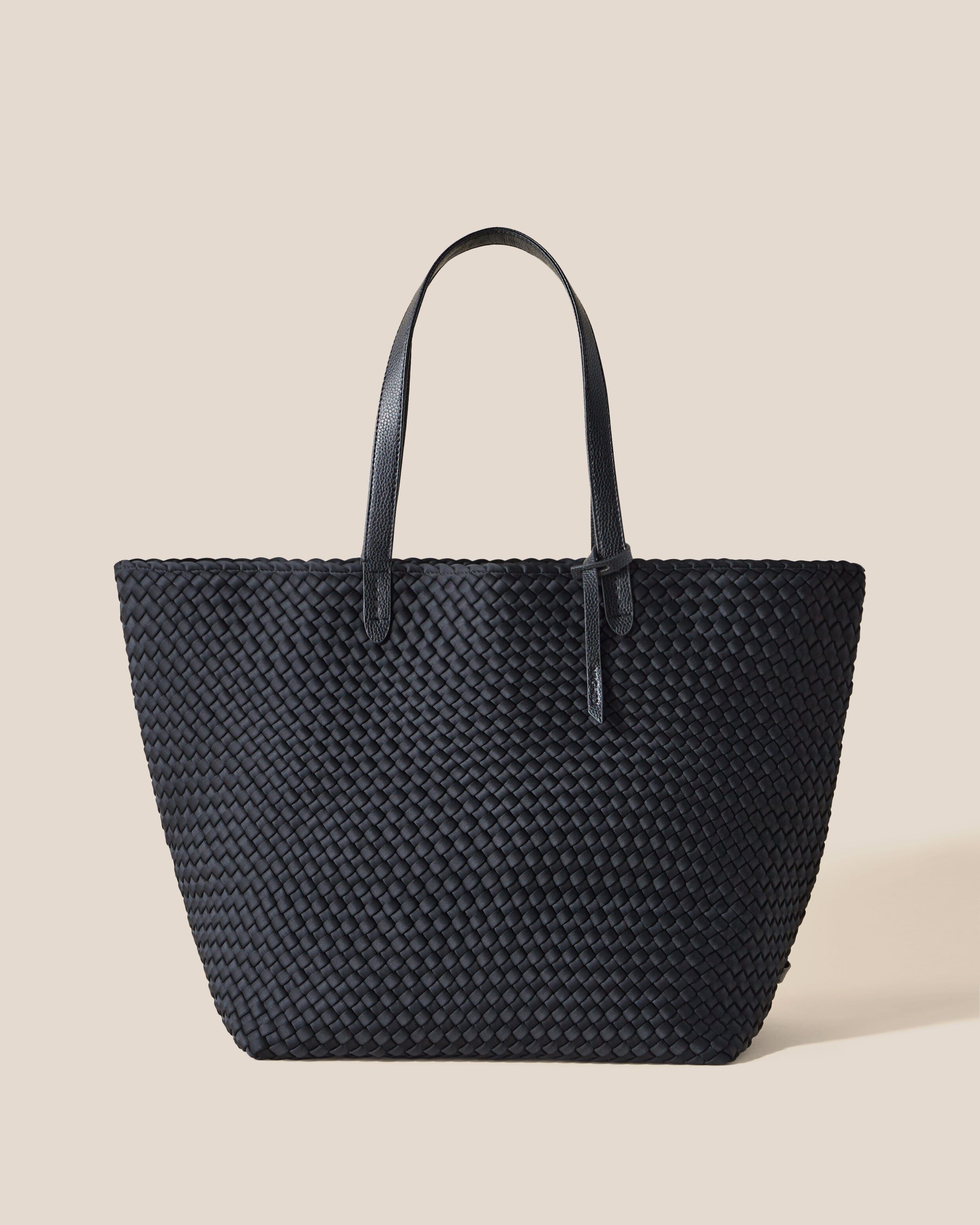 Jetsetter Tote in Onyx, a true black tone, in handwoven neoprene, featuring a top zip closure, and vegan leather handles.