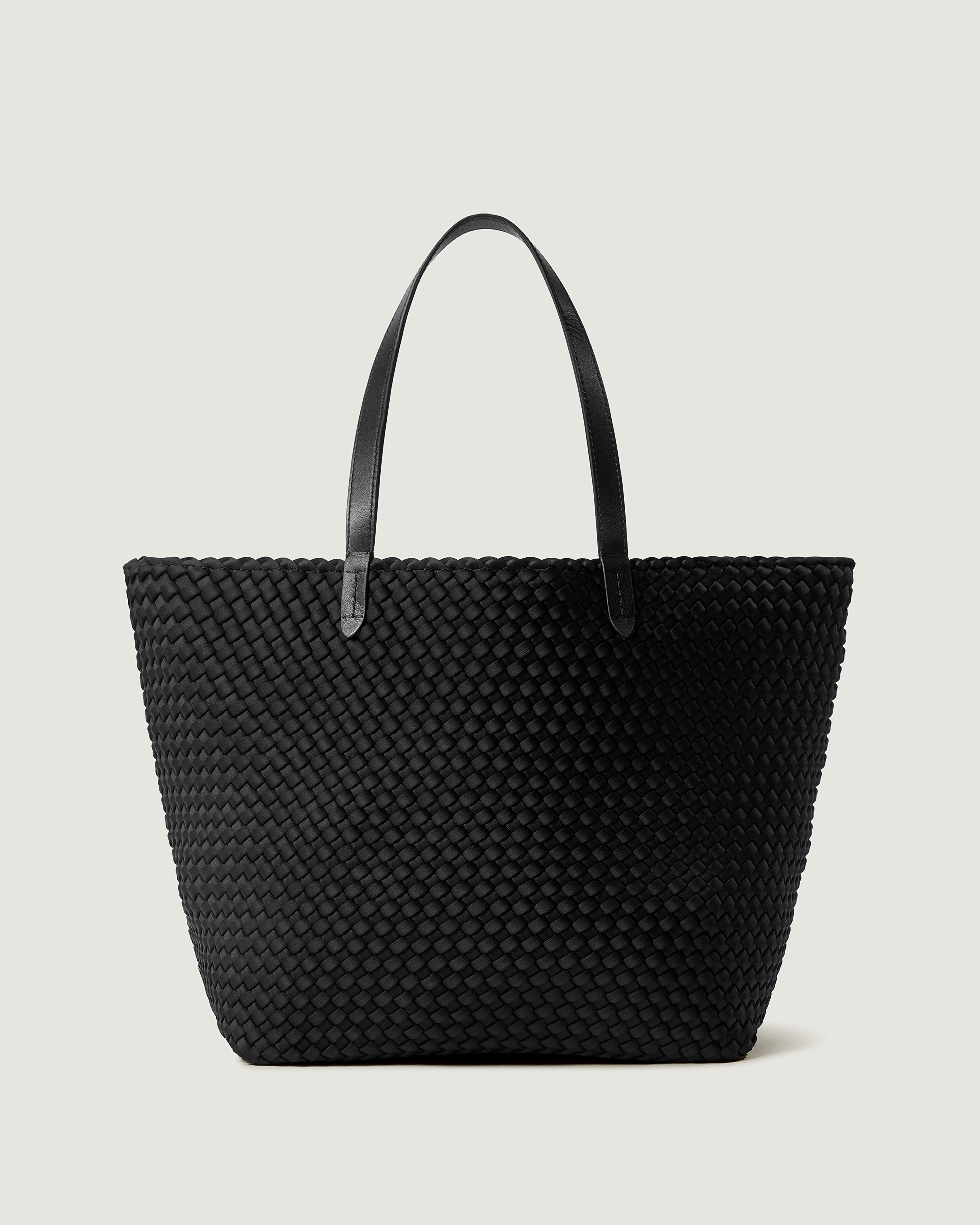 Jetsetter Tote in Onyx, a true black, in handwoven neoprene, featuring a top zip closure, and leather handles.