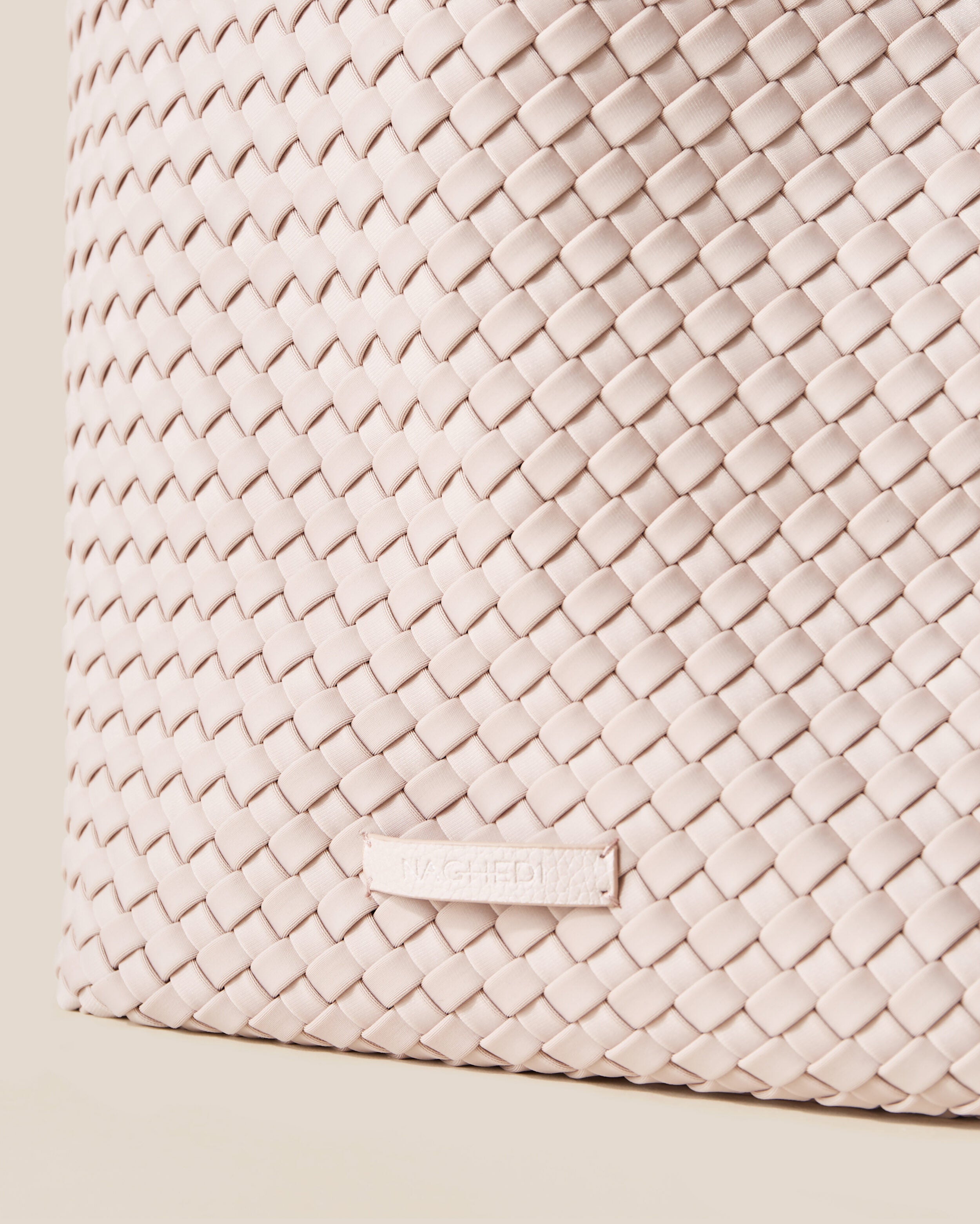 Close-up of stamped NAGHEDI logo on Jetsetter Tote in Shell Pink.