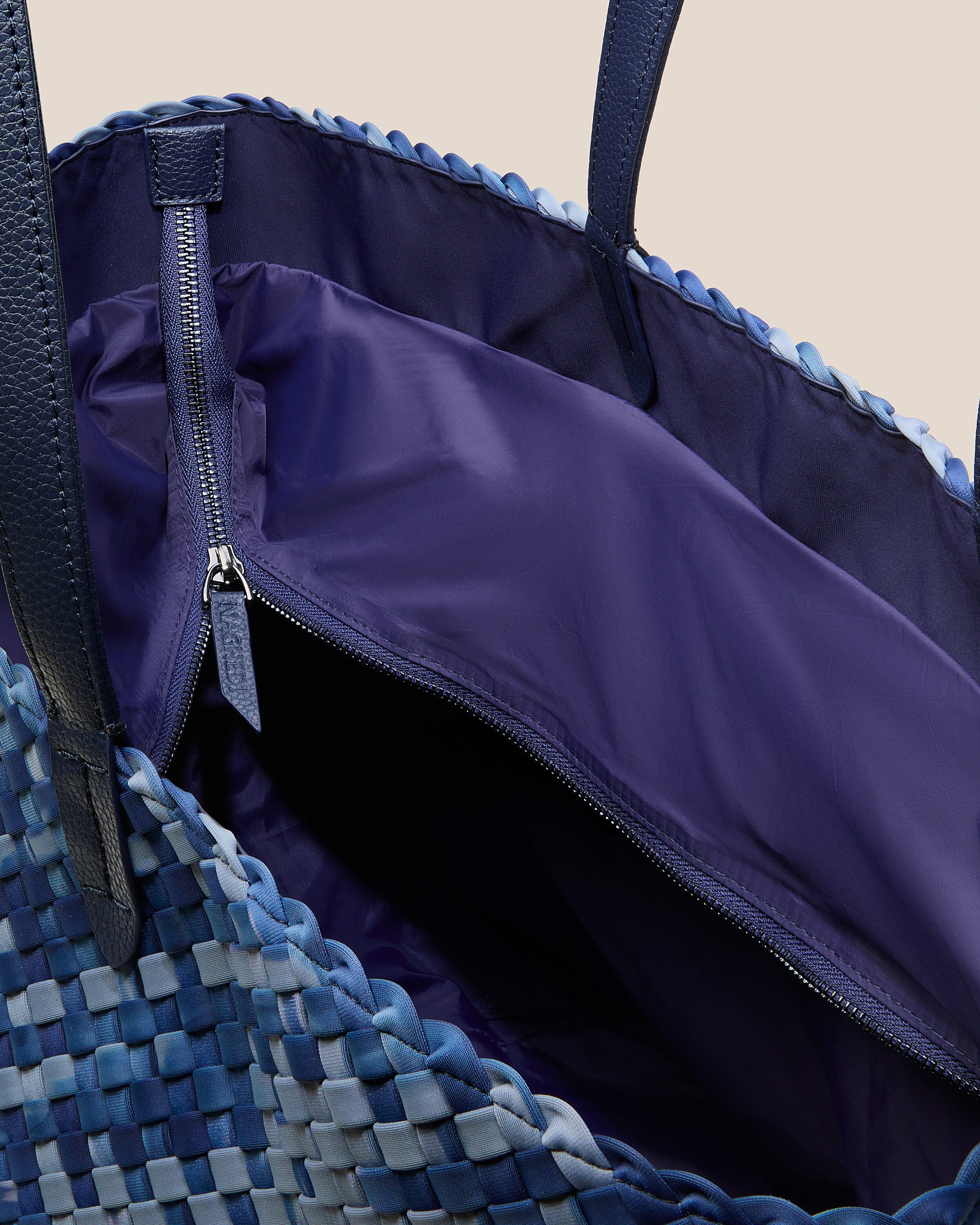 Interior close-up of Jetsetter Tote in Paros showing its top zip closure, interior pockets, and wipe-clean nylon interior.