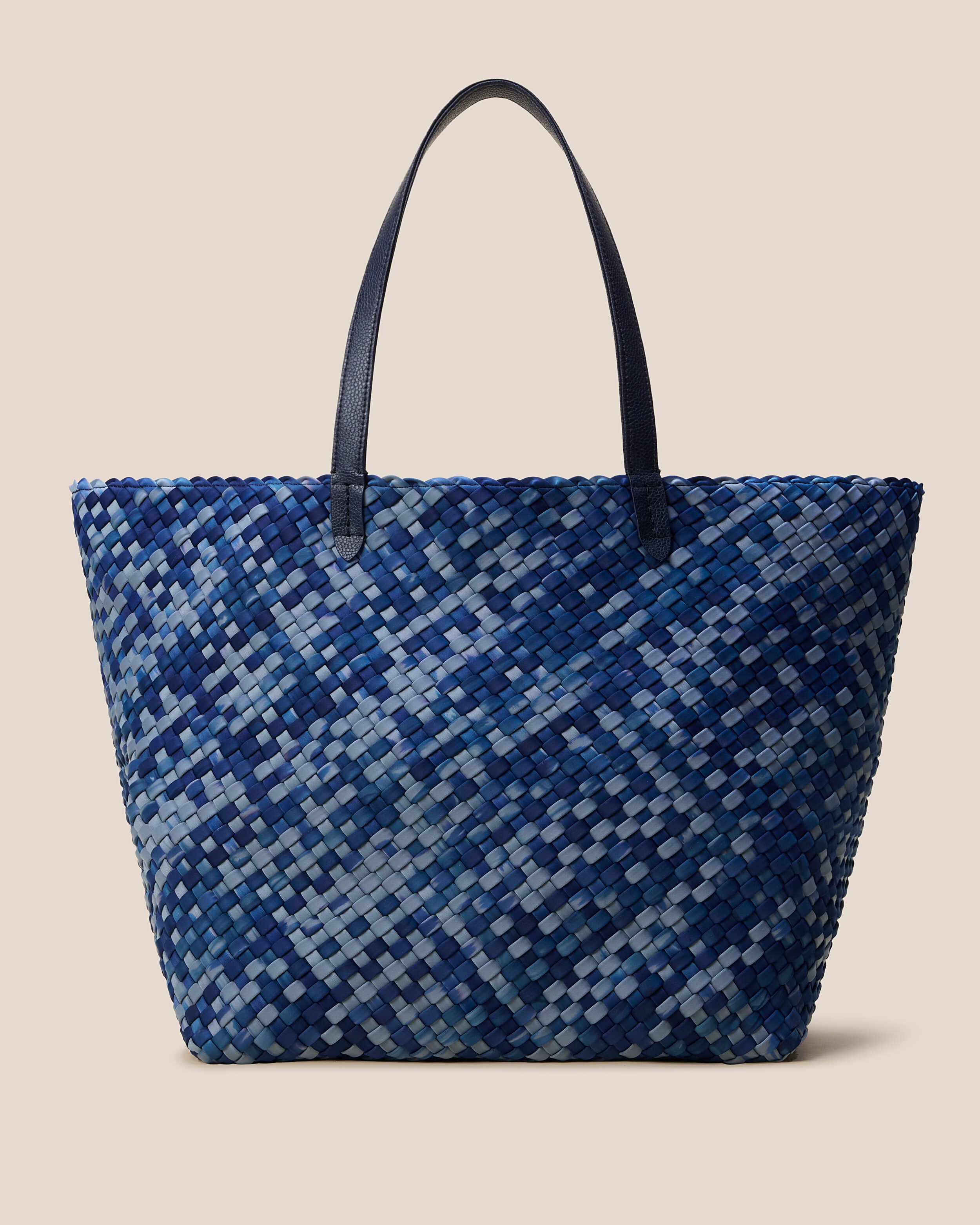 Jetsetter Tote in Paros, a denim blue and navy tone, in handwoven neoprene, featuring a top zip closure, and vegan leather handles.
