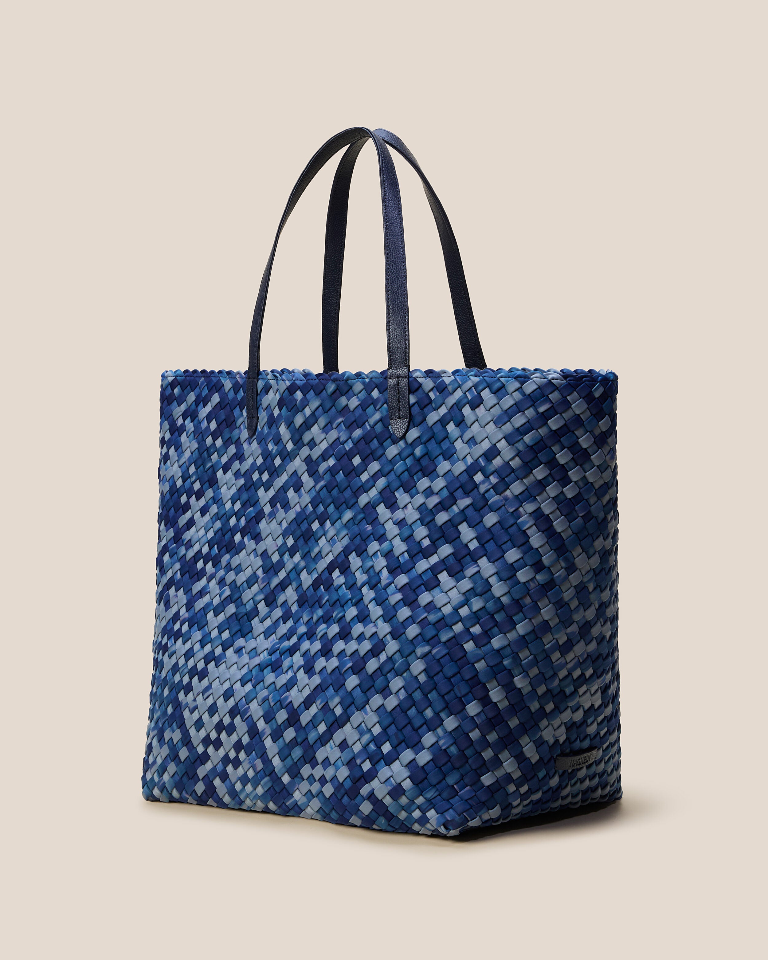 Jetsetter Tote in Paros shown from a side angle, highlighting its handwoven neoprene construction and top zip closure.