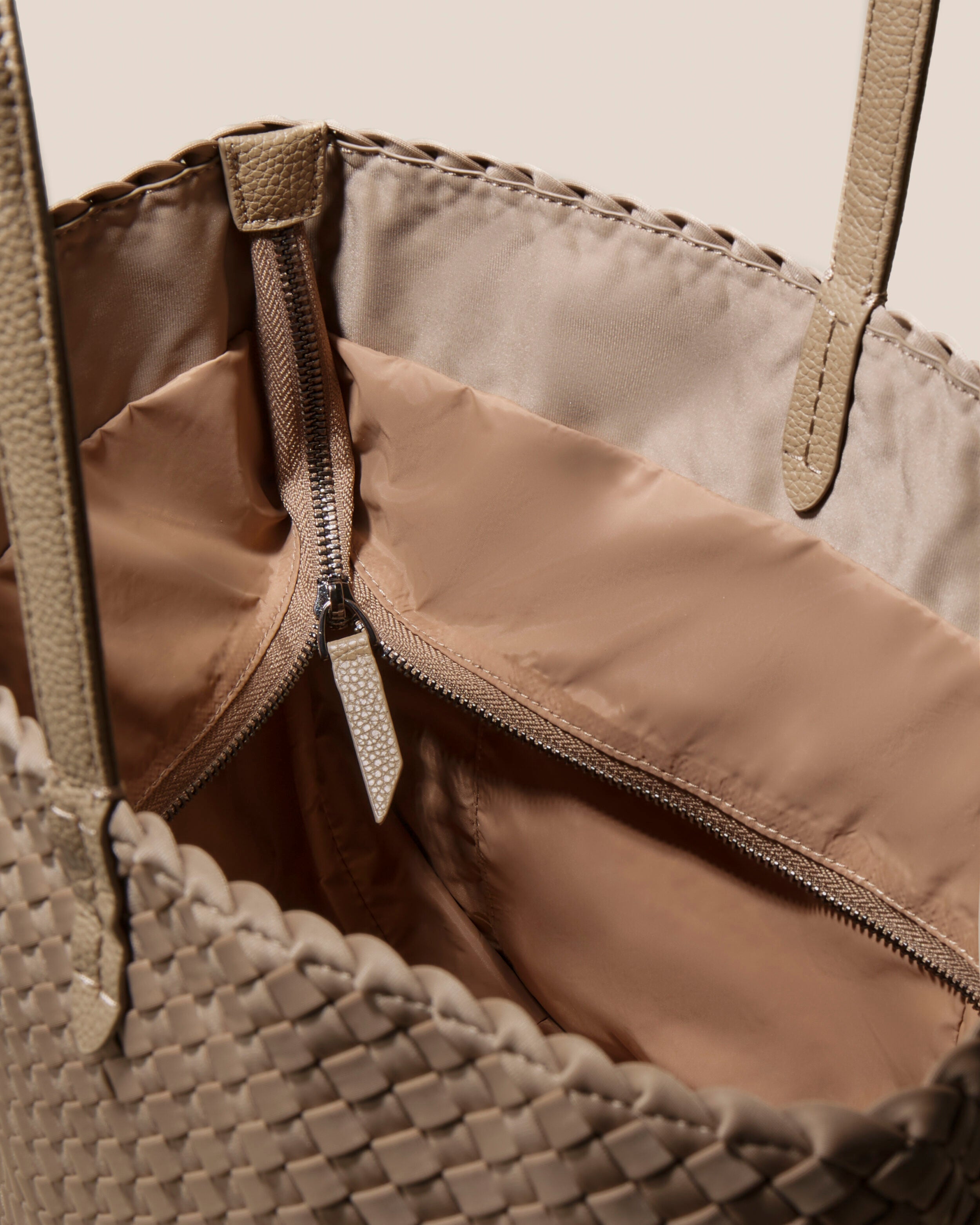 Interior close-up of Jetsetter Tote in Cashmere showing its top zip closure, interior pockets, and wipe-clean nylon interior.