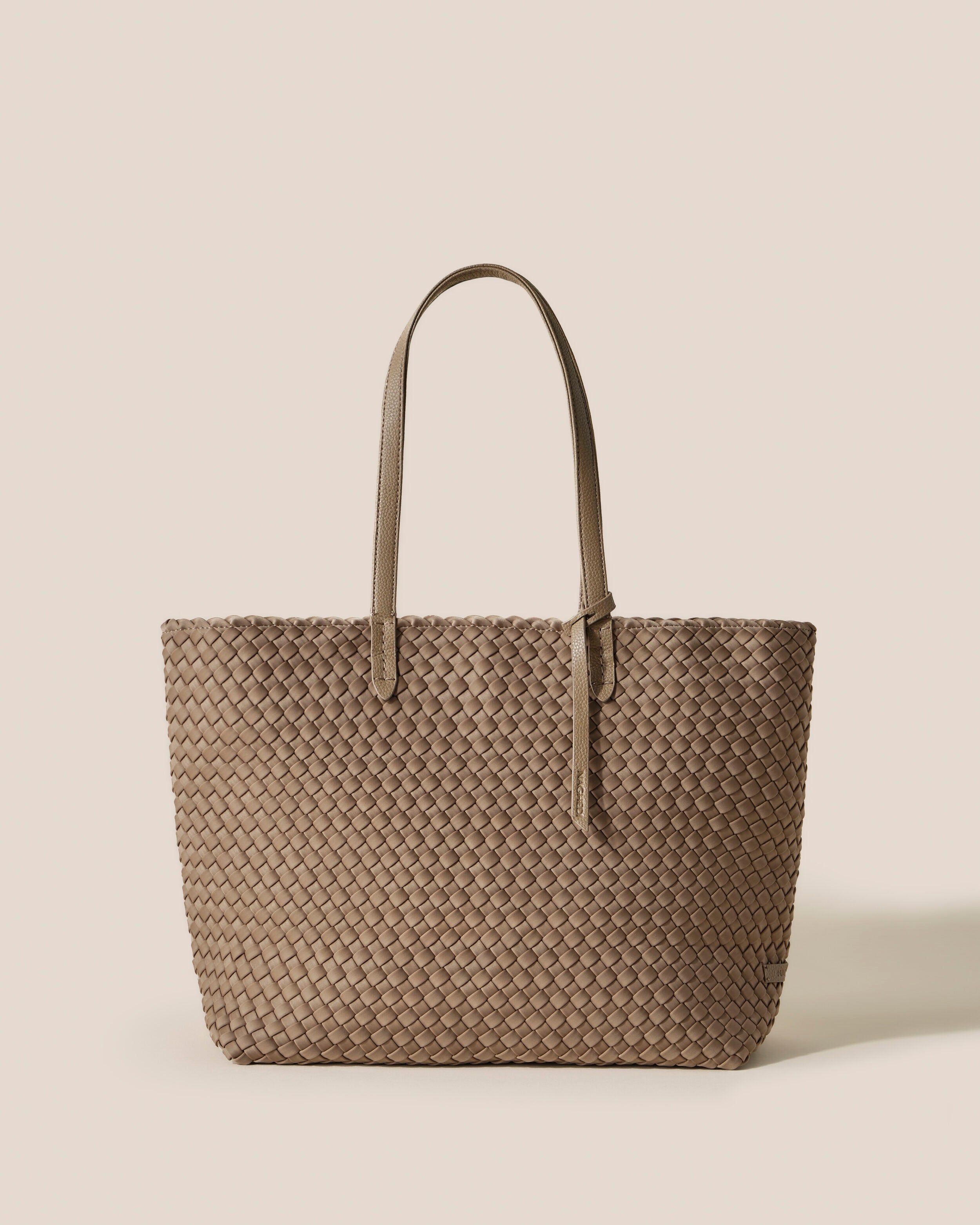 Jetsetter Tote in Cashmere, a taupe tone, in handwoven neoprene, featuring a top zip closure, and vegan leather handles.