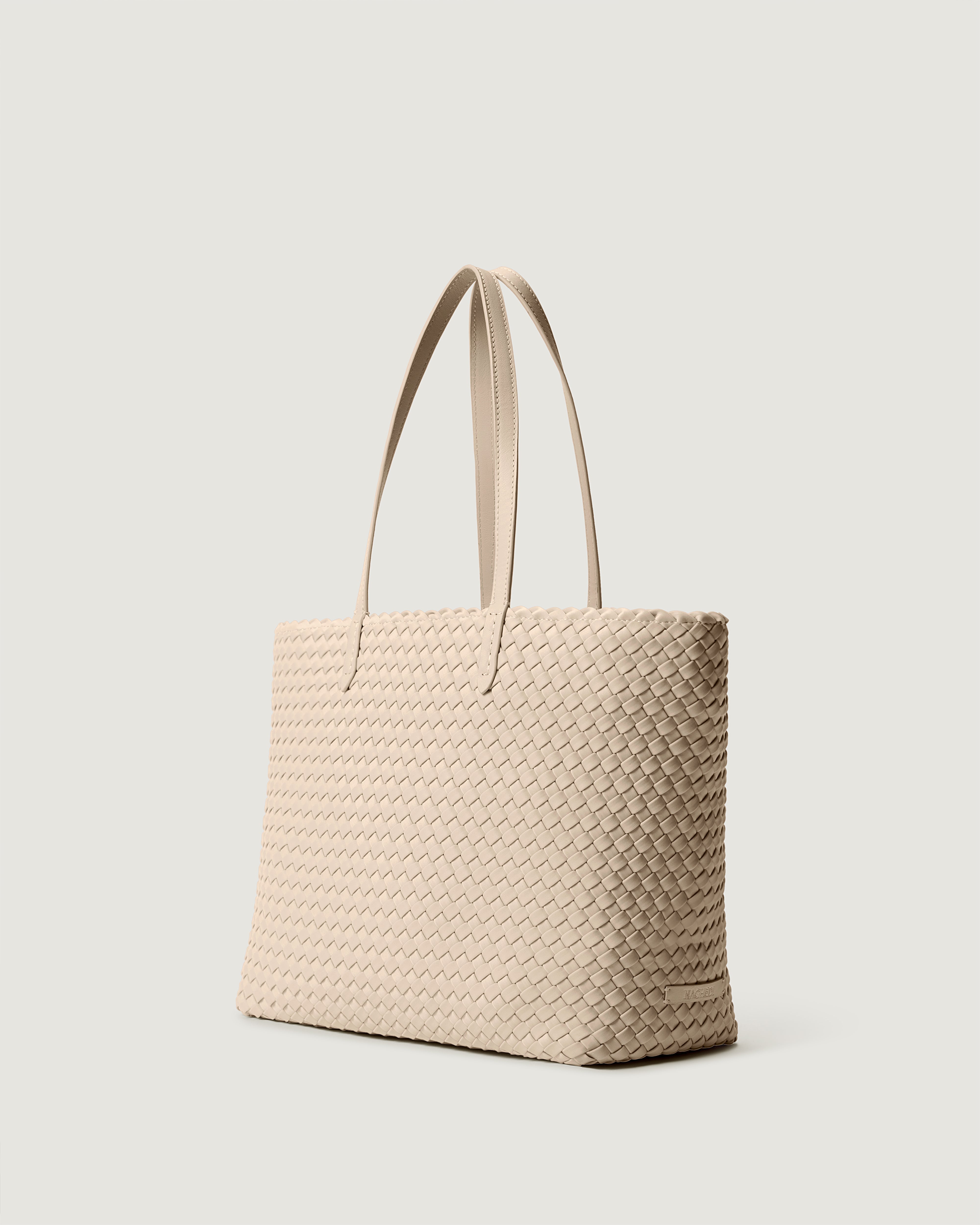 Jetsetter Tote in Ecru shown from a side angle, highlighting its handwoven neoprene construction and top zip closure.