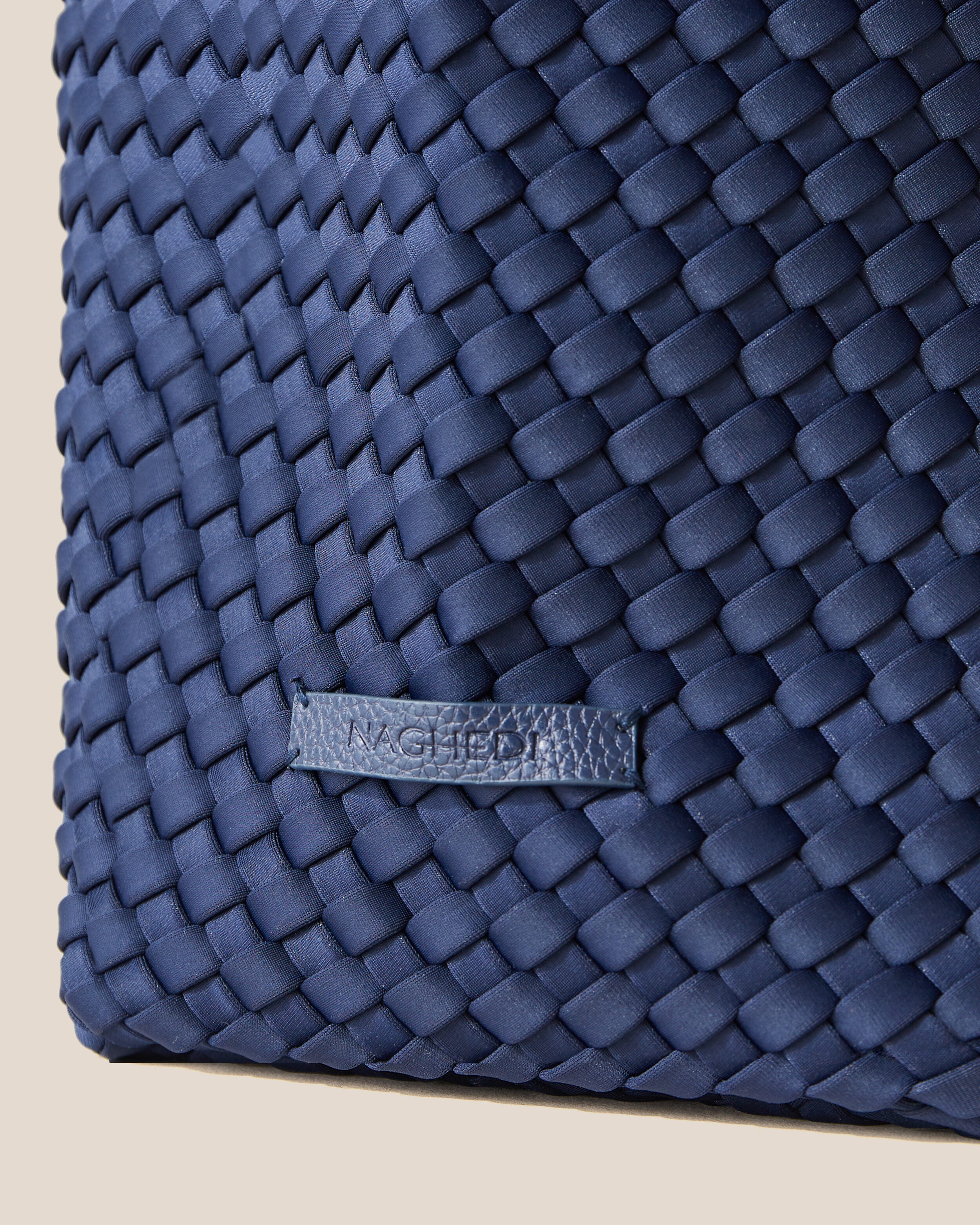 Close-up of stamped NAGHEDI logo on Jetsetter Tote in Ink Blue.
