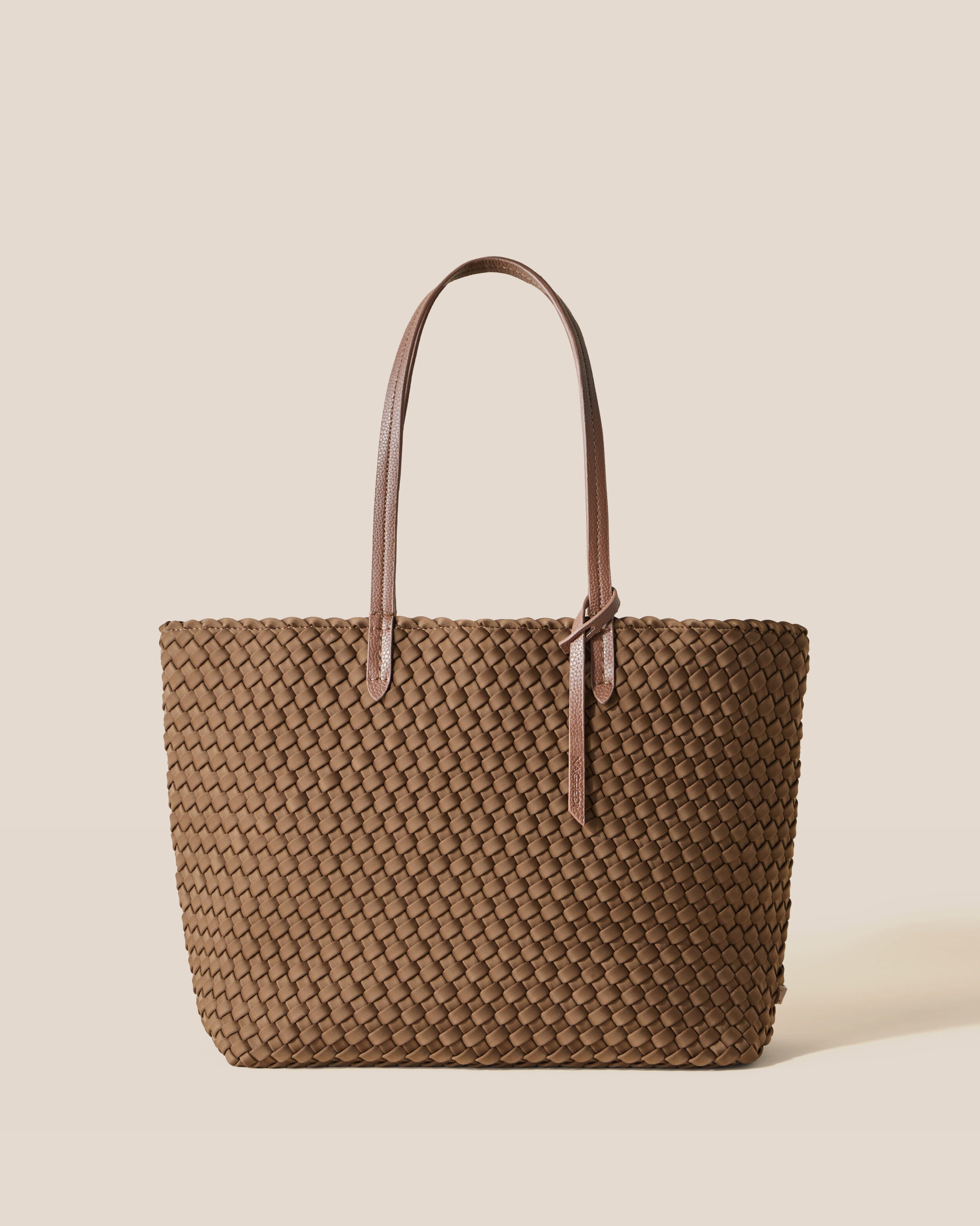 Jetsetter Tote in Mink, a brown tone, in handwoven neoprene, featuring a top zip closure, and vegan leather handles.