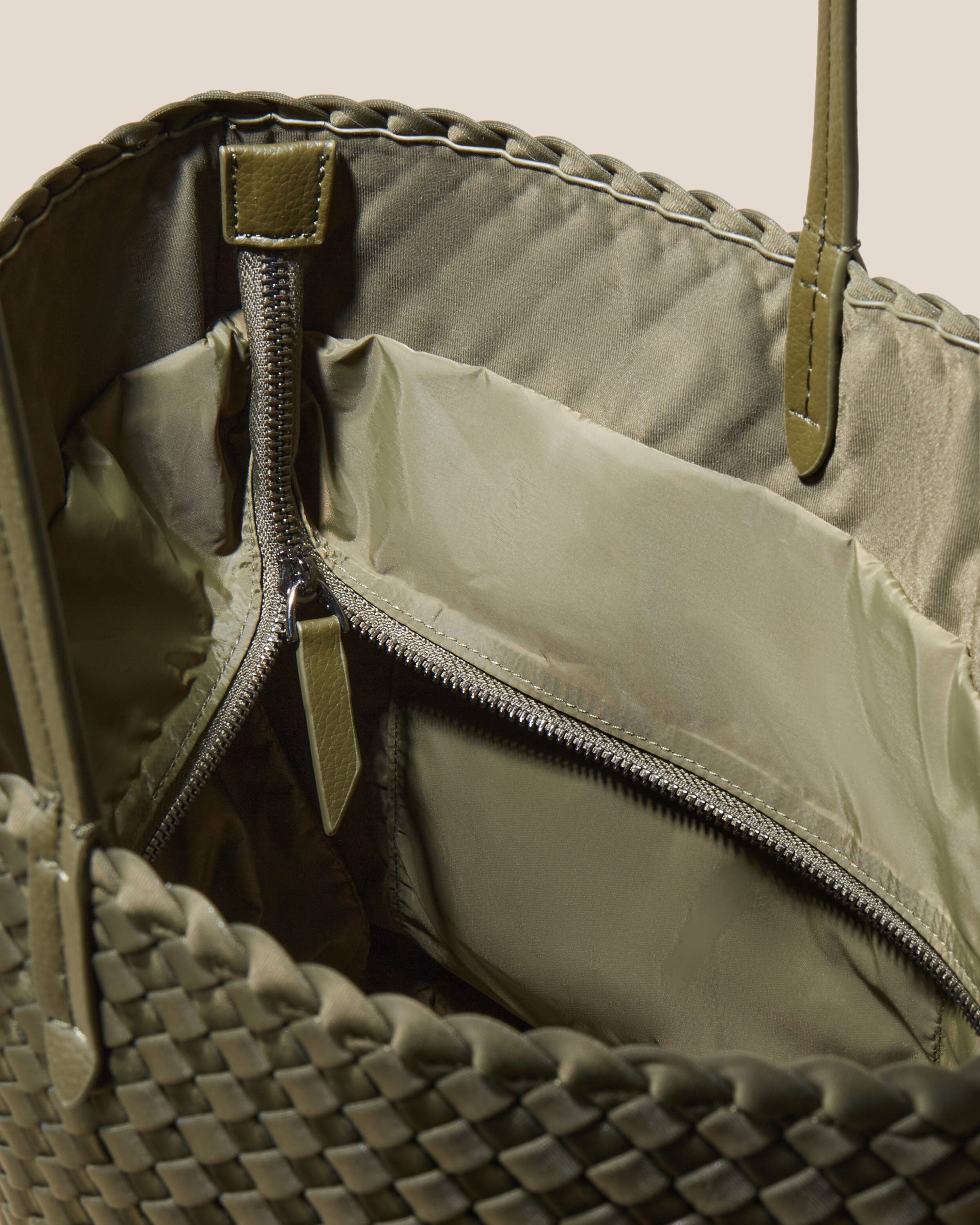 Interior close-up of Jetsetter Tote in Olive showing its top zip closure, interior pockets, and wipe-clean nylon interior.