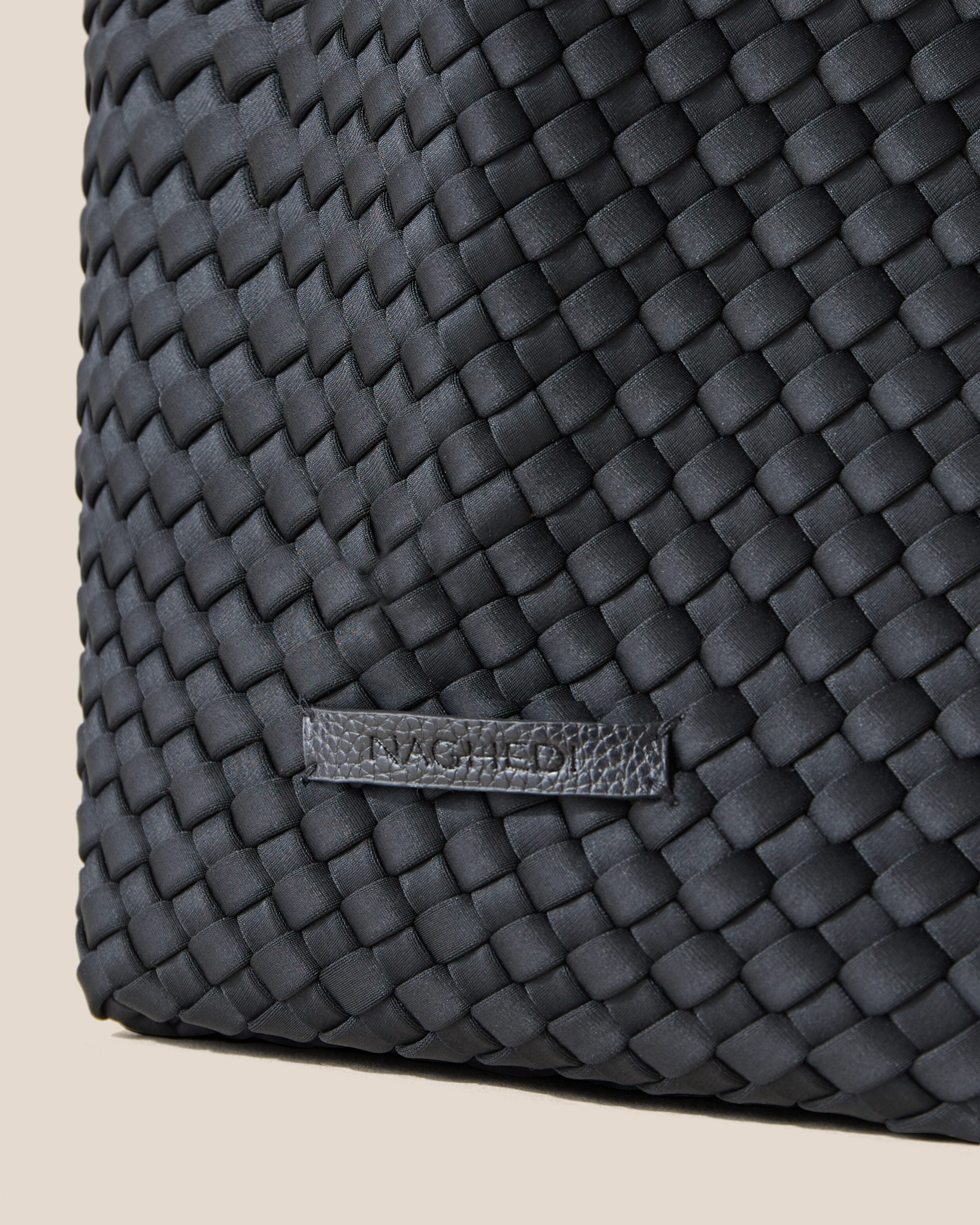 Close-up of stamped NAGHEDI logo on Jetsetter Tote in Onyx.