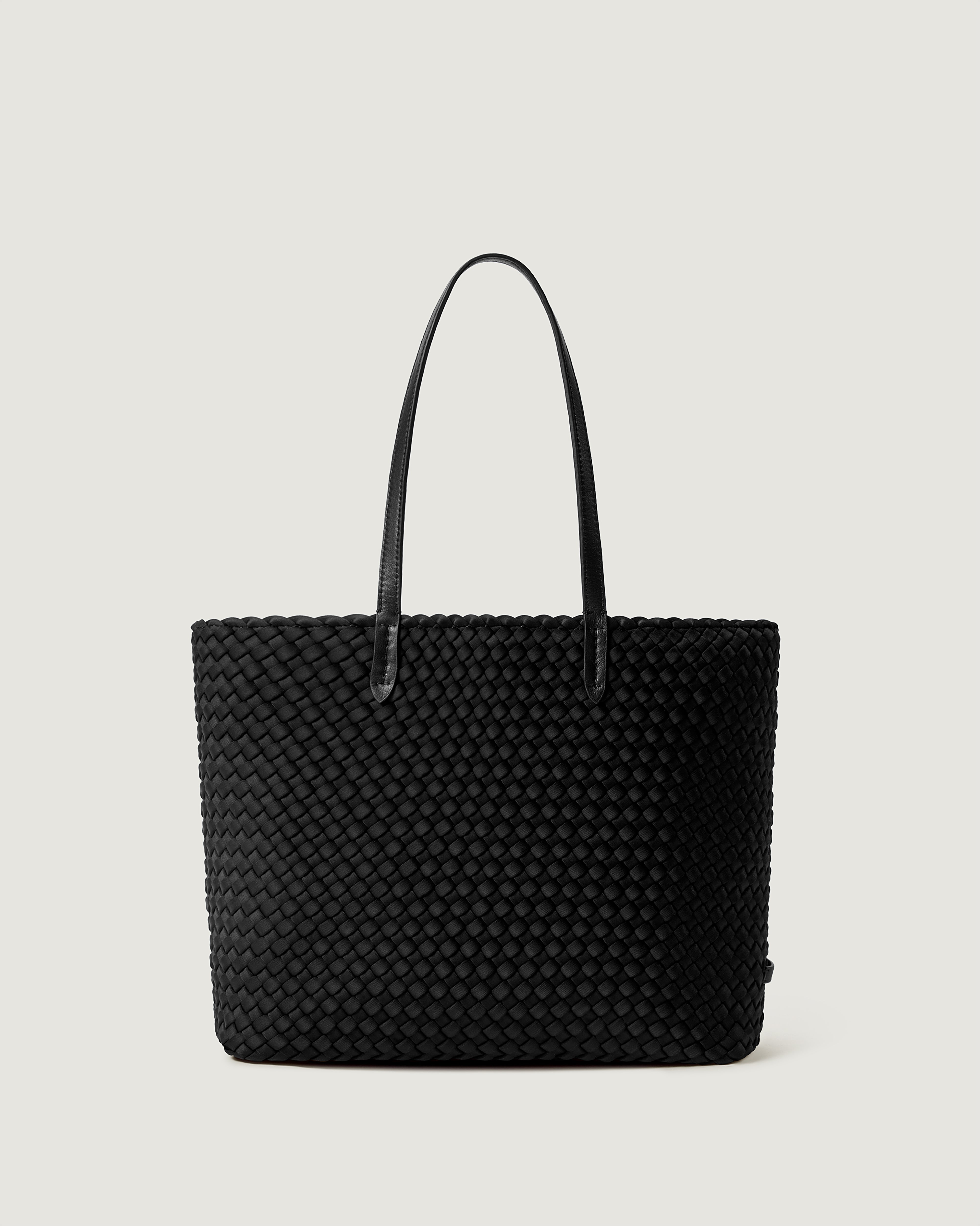 Jetsetter Tote in Onyx, a true black, in handwoven neoprene, featuring a top zip closure, and leather handles.