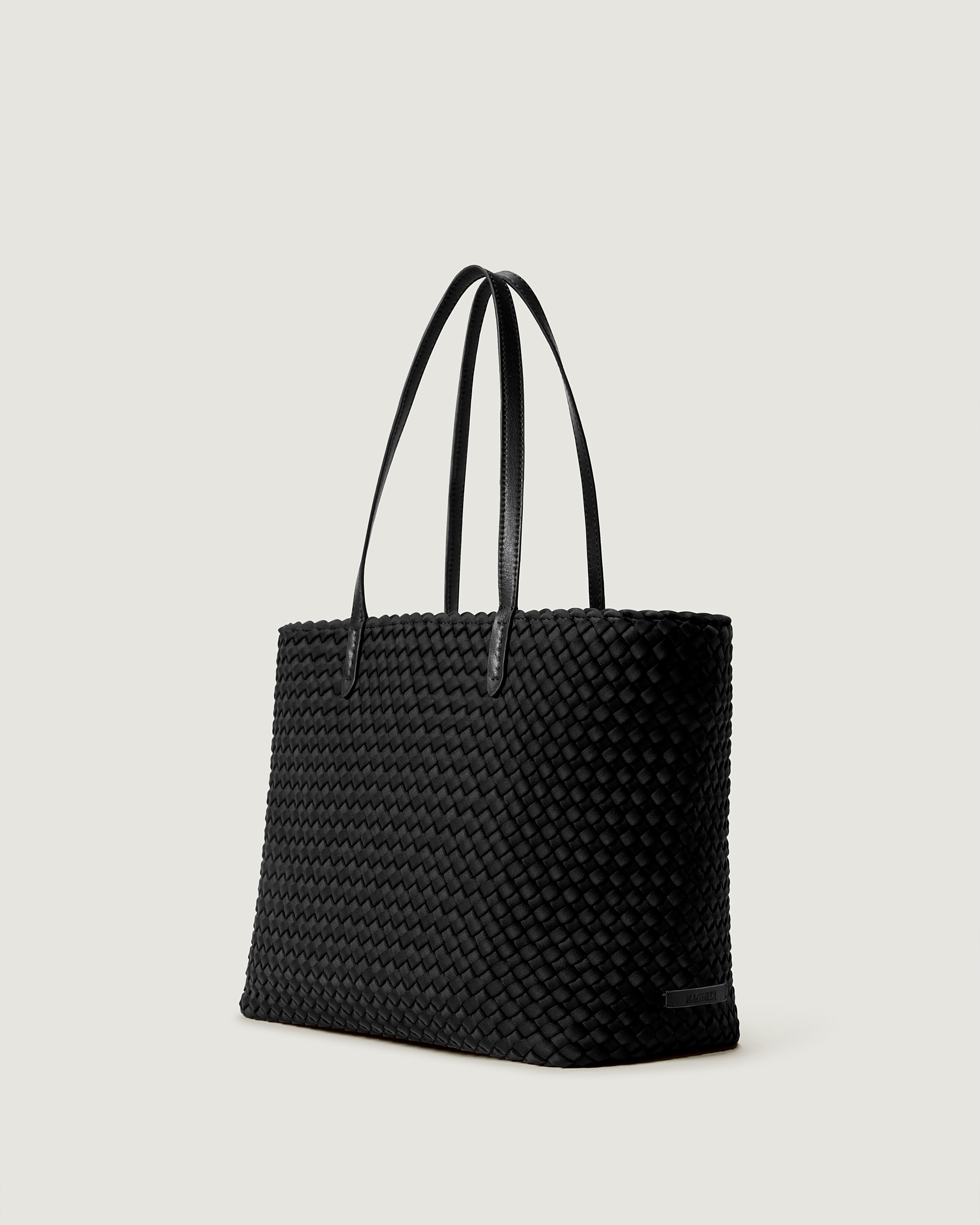 Jetsetter Tote in Onyx shown from a side angle, highlighting its handwoven neoprene construction and top zip closure.