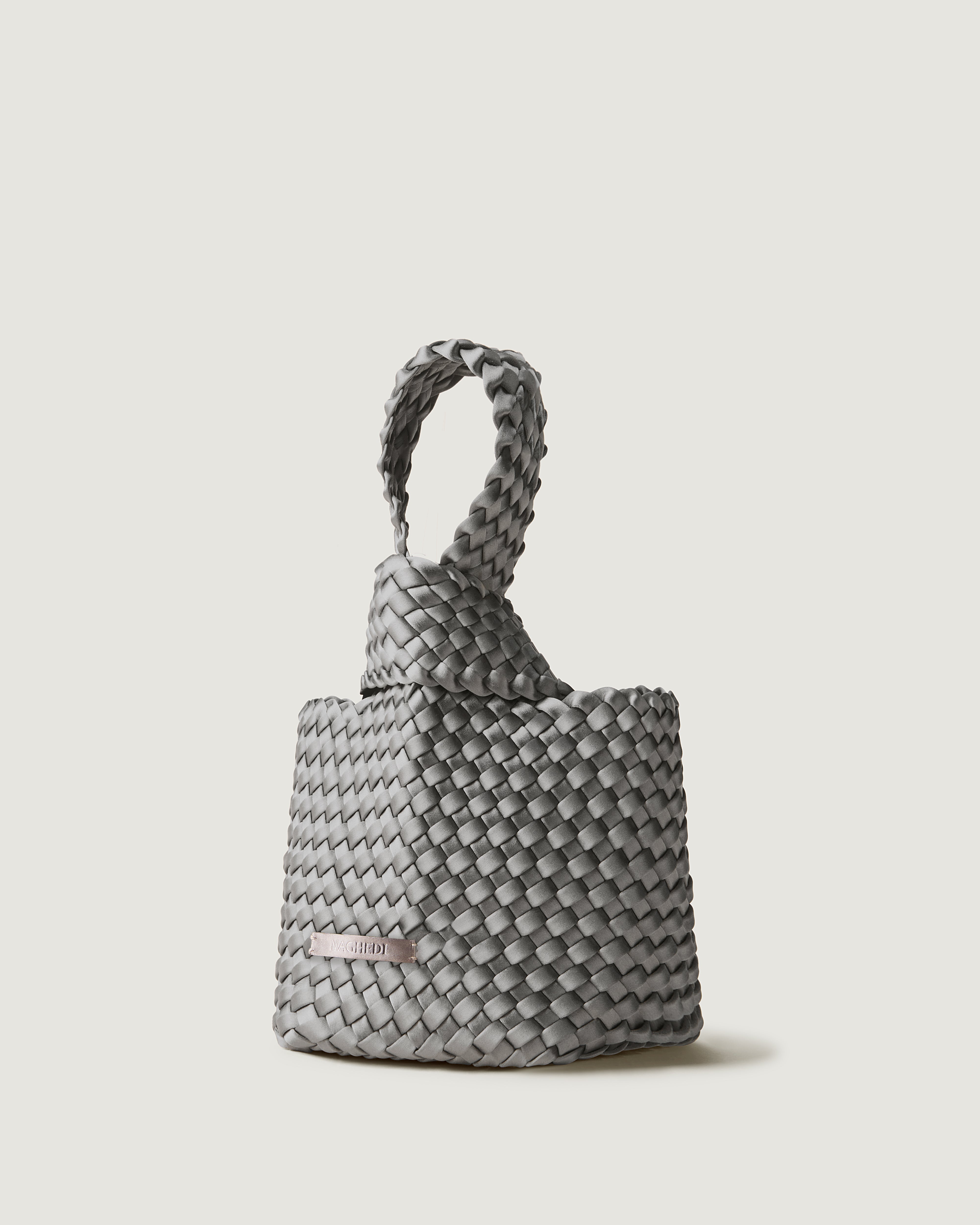 Kyoto Clutch in Graphite shown from a side angle, highlighting its handwoven satin construction and secure slide-through loop closure.