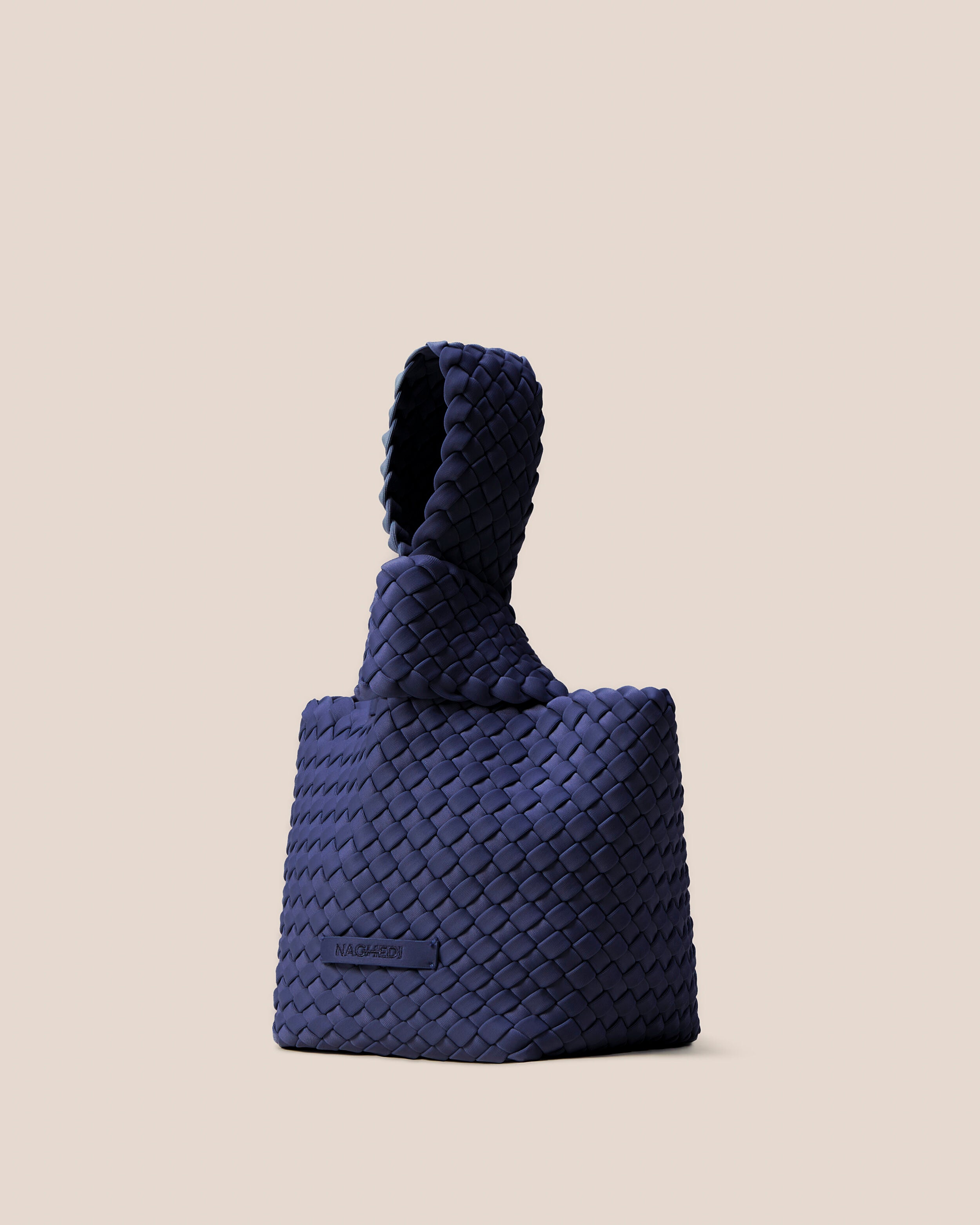Kyoto Clutch in Ink Blue shown from a side angle, highlighting its handwoven neoprene construction and secure slide-through loop closure.