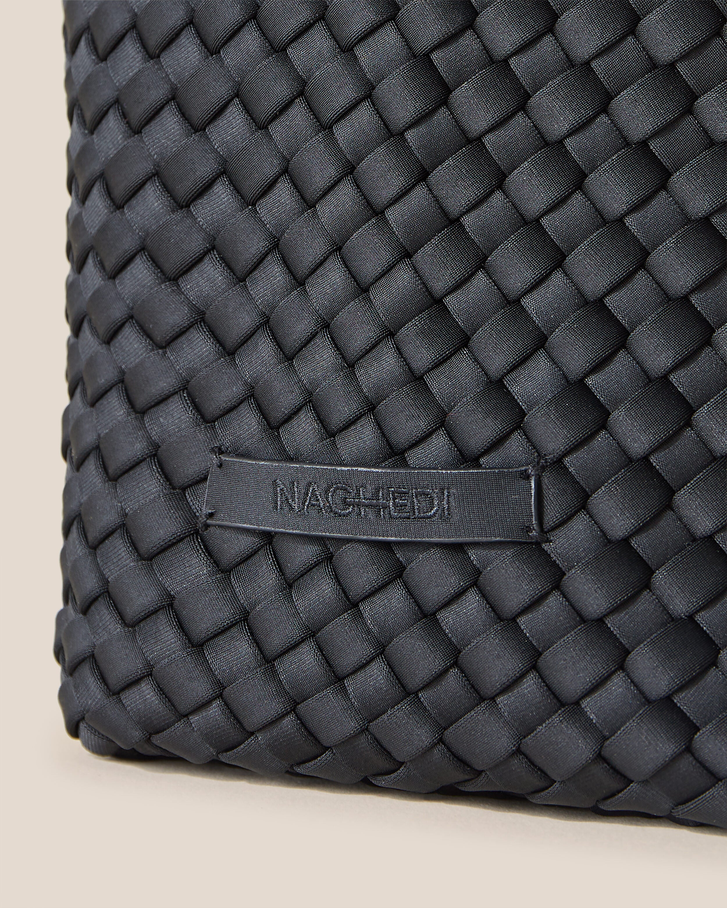 Close-up of stamped NAGHEDI logo on Kyoto Clutch in Onyx.