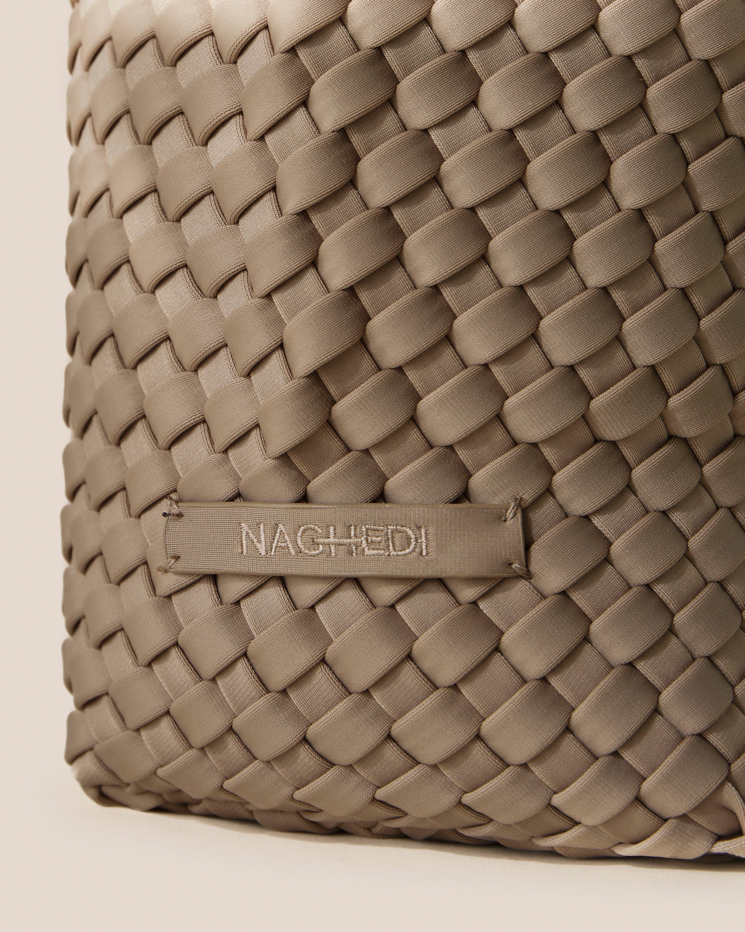 Close-up of stamped NAGHEDI logo on Laguna Crossbody in Cashmere.