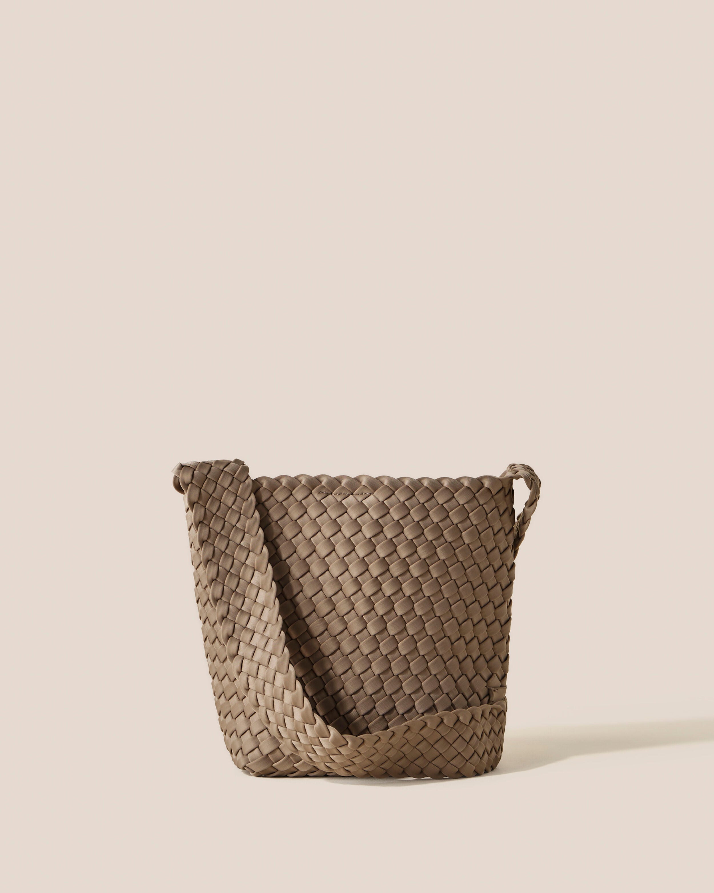 Laguna Crossbody in Cashmere, a taupe tone, in handwoven neoprene, featuring an open top with magnetic snap closure, and handwoven crossbody strap lays comfortably flat.