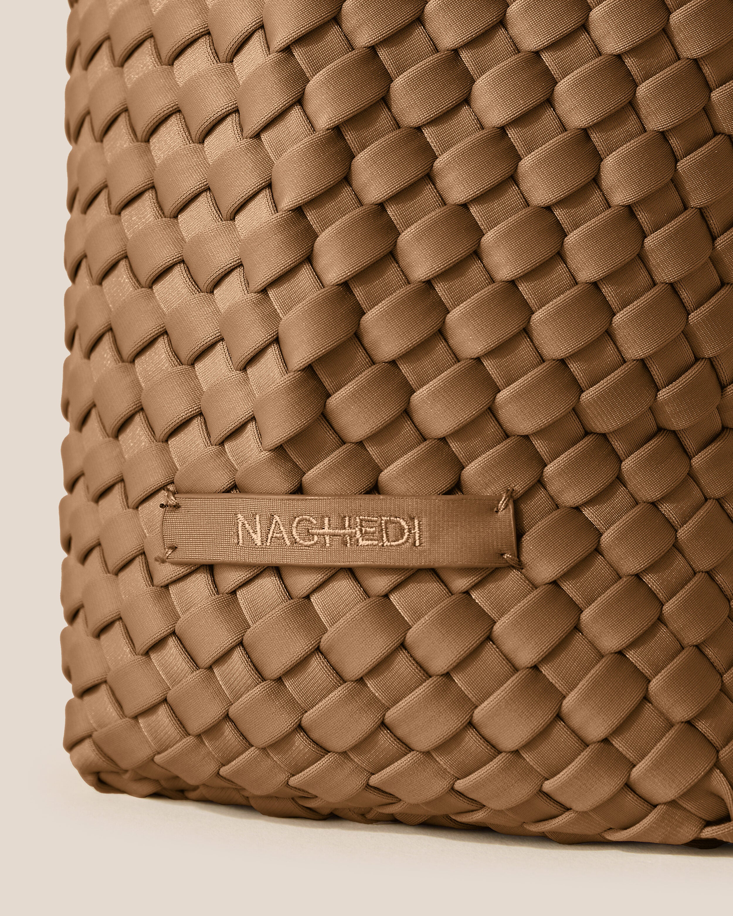 Close-up of stamped NAGHEDI logo on Laguna Crossbody in Mink.