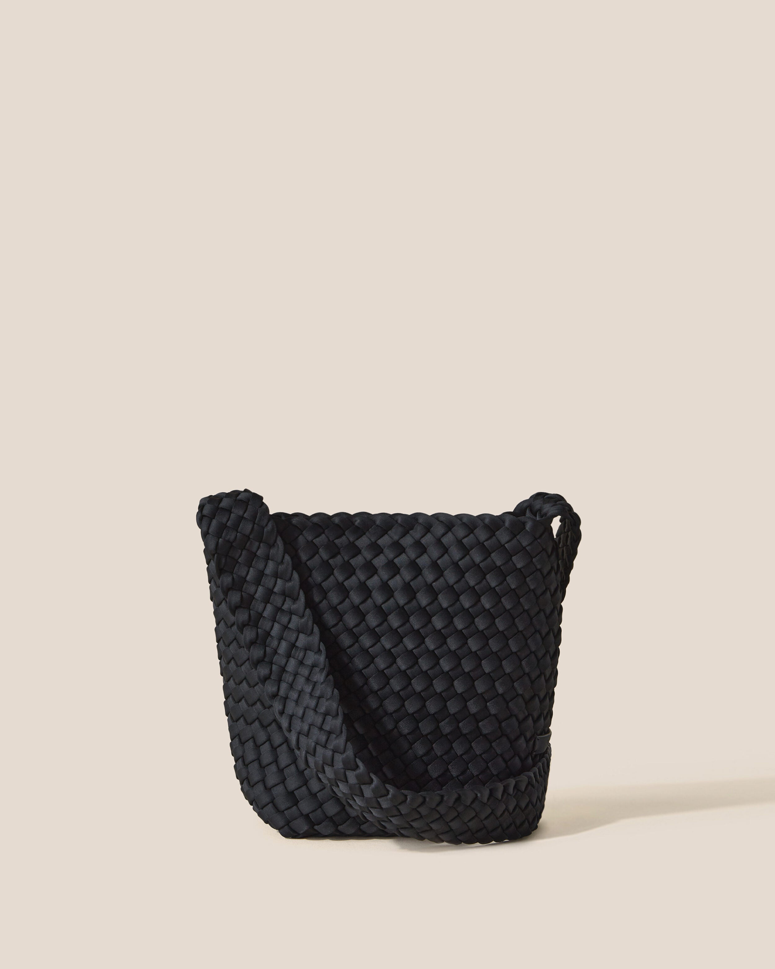 Laguna Crossbody in Onyx, a true black tone, in handwoven neoprene, featuring an open top with magnetic snap closure, and handwoven crossbody strap lays comfortably flat.