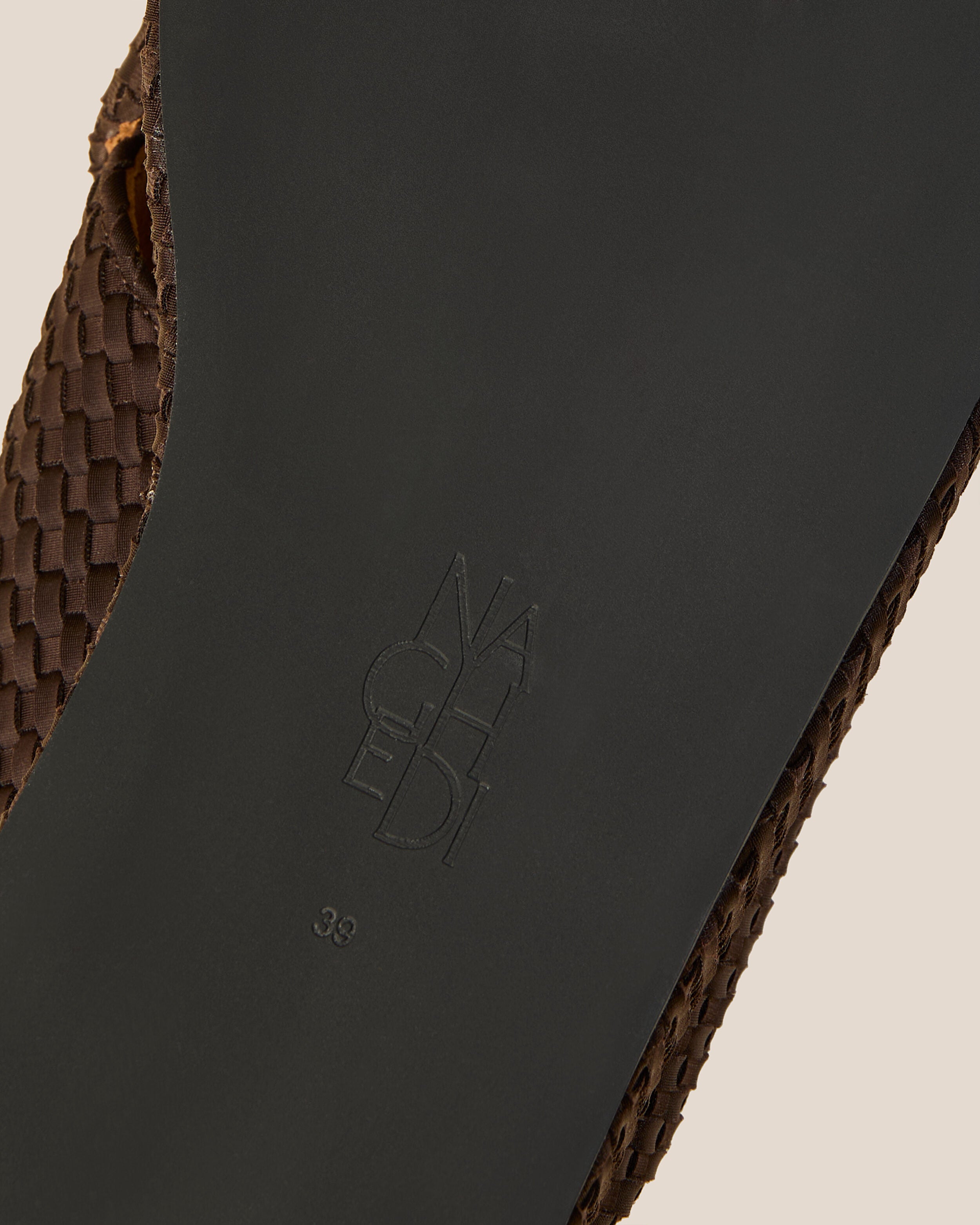 Shoe sole showing natural rubber sole, stamped NAGHEDI logo and size detail for The Laguna Platform in Chocolate.