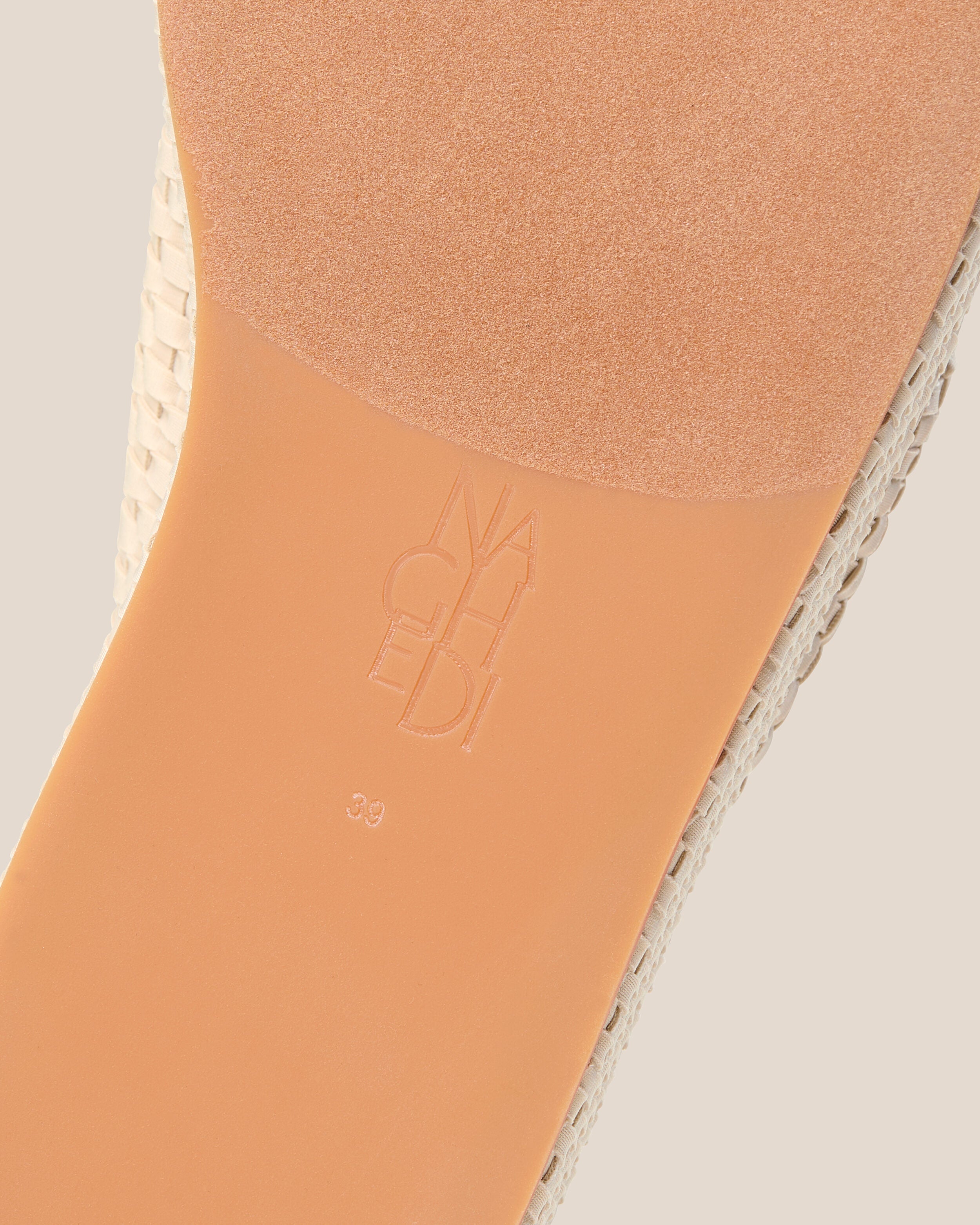 Shoe sole showing natural rubber sole, stamped NAGHEDI logo and size detail for The Laguna Platform in Ecru.