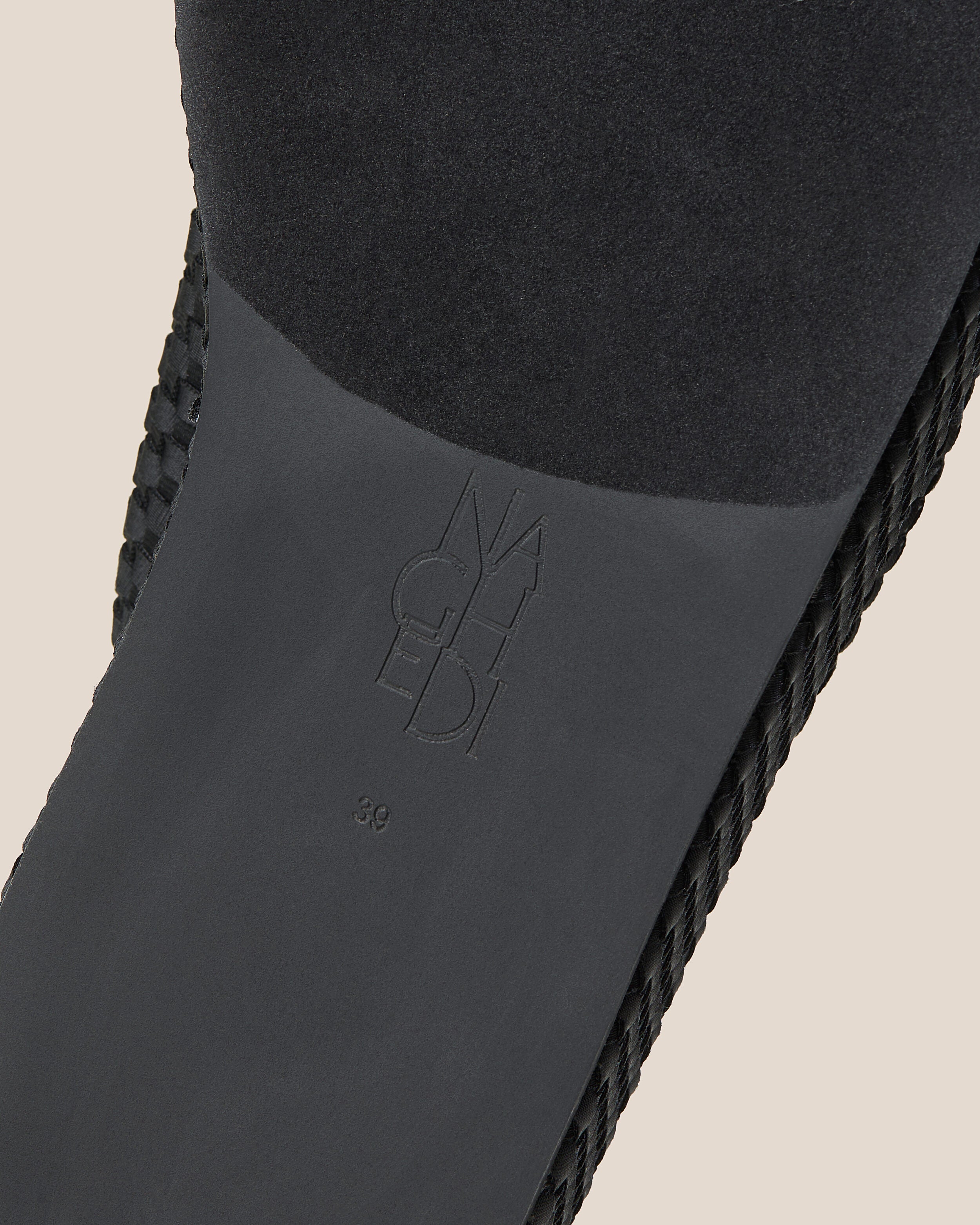 Shoe sole showing natural rubber sole, stamped NAGHEDI logo and size detail for The Laguna Platform in Onyx.