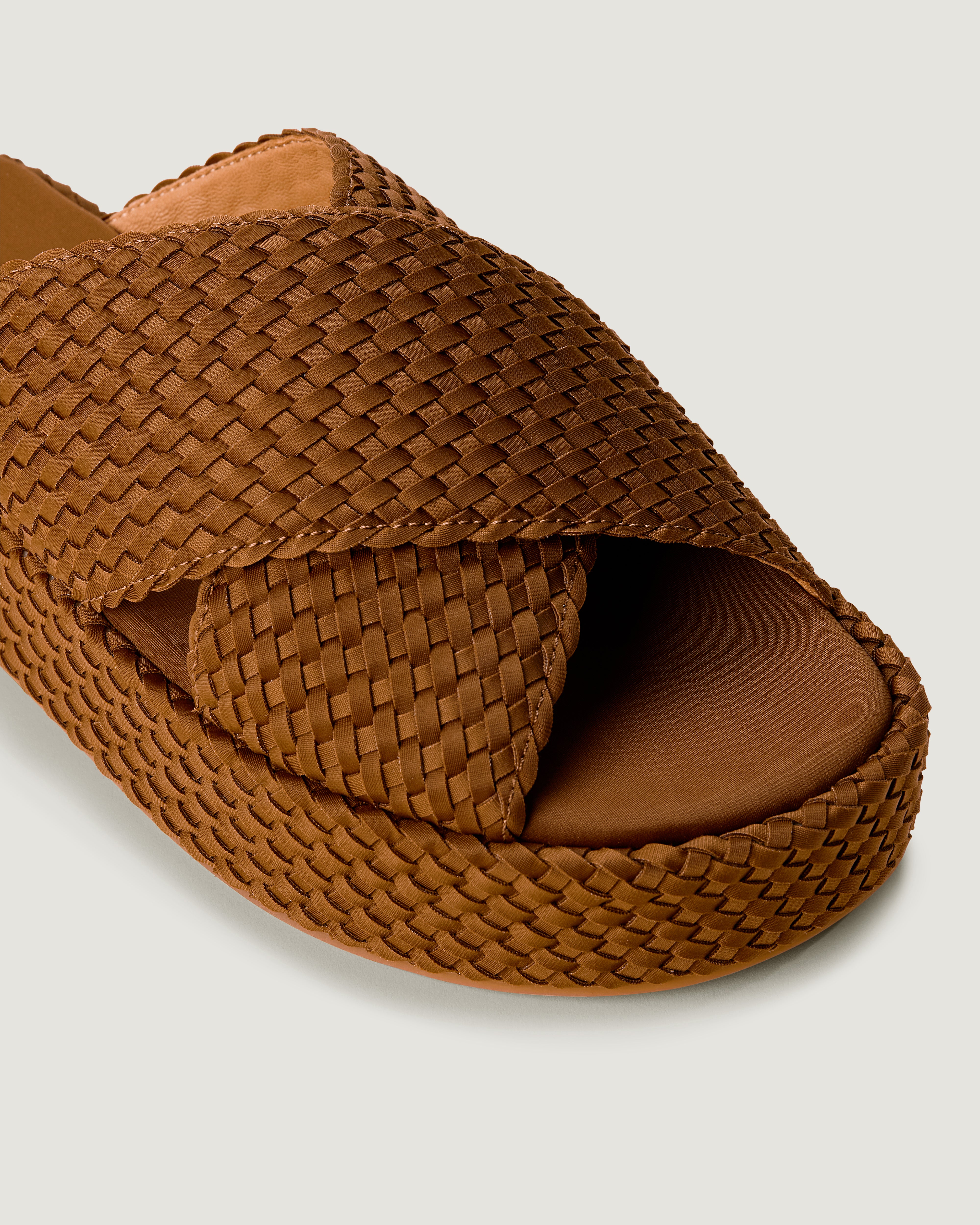 Close-up of The Laguna Platform in Teak showing its open toe and round silhouette.