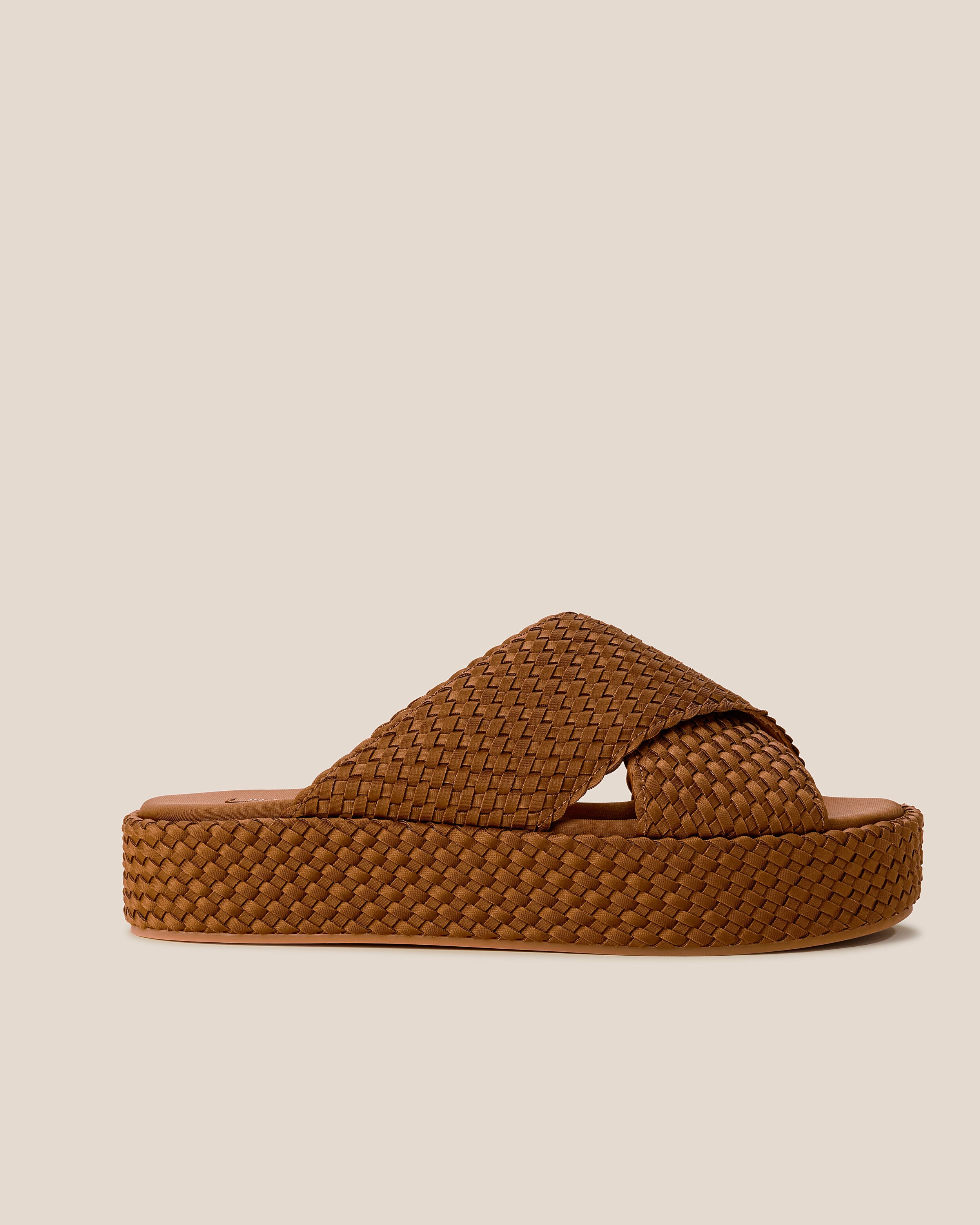 Side view of The Laguna Platform in Teak, a saddle brown tone, featuring an open toe and round silhouette.