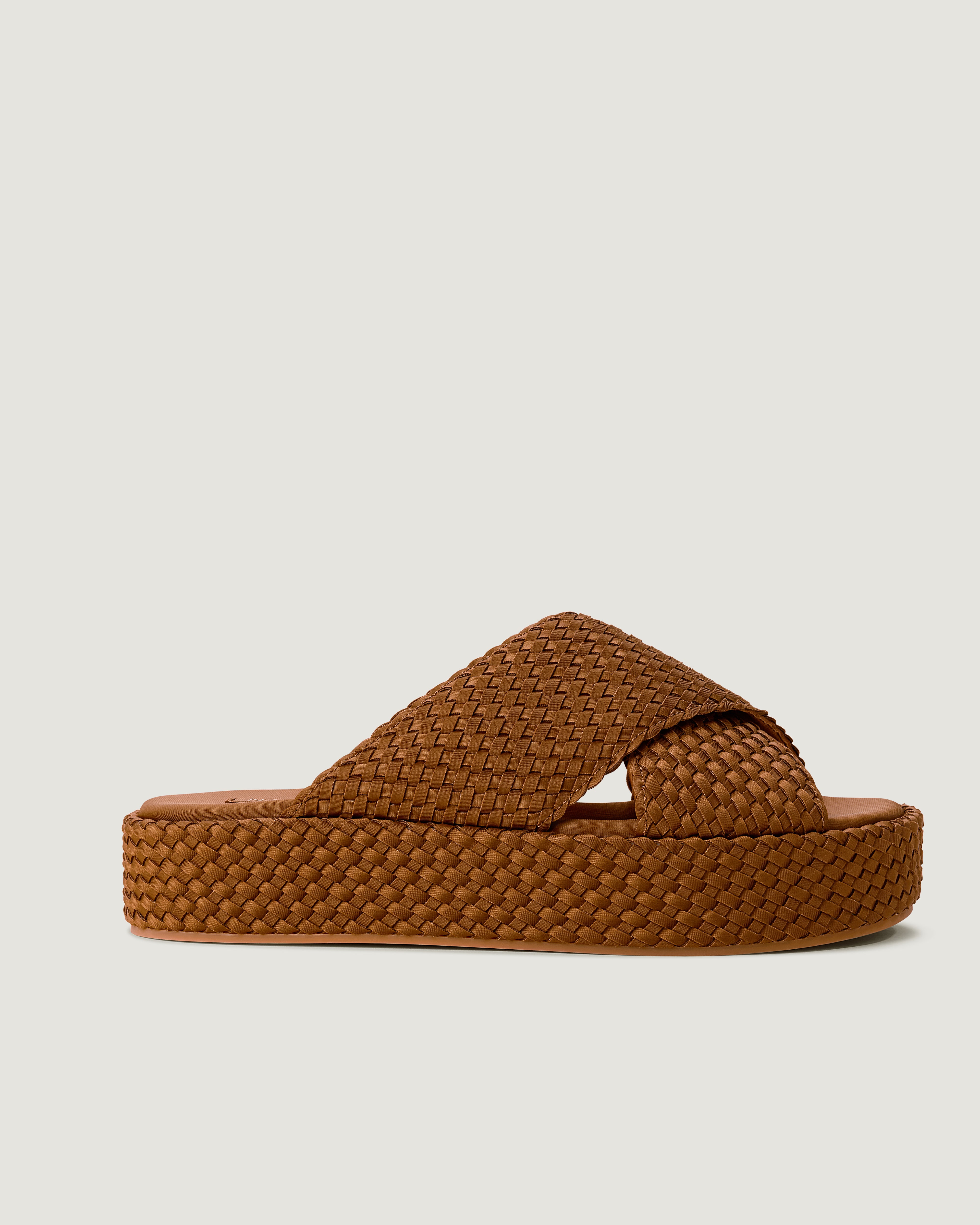 Side view of The Laguna Platform in Teak, a saddle brown tone, featuring an open toe and round silhouette.