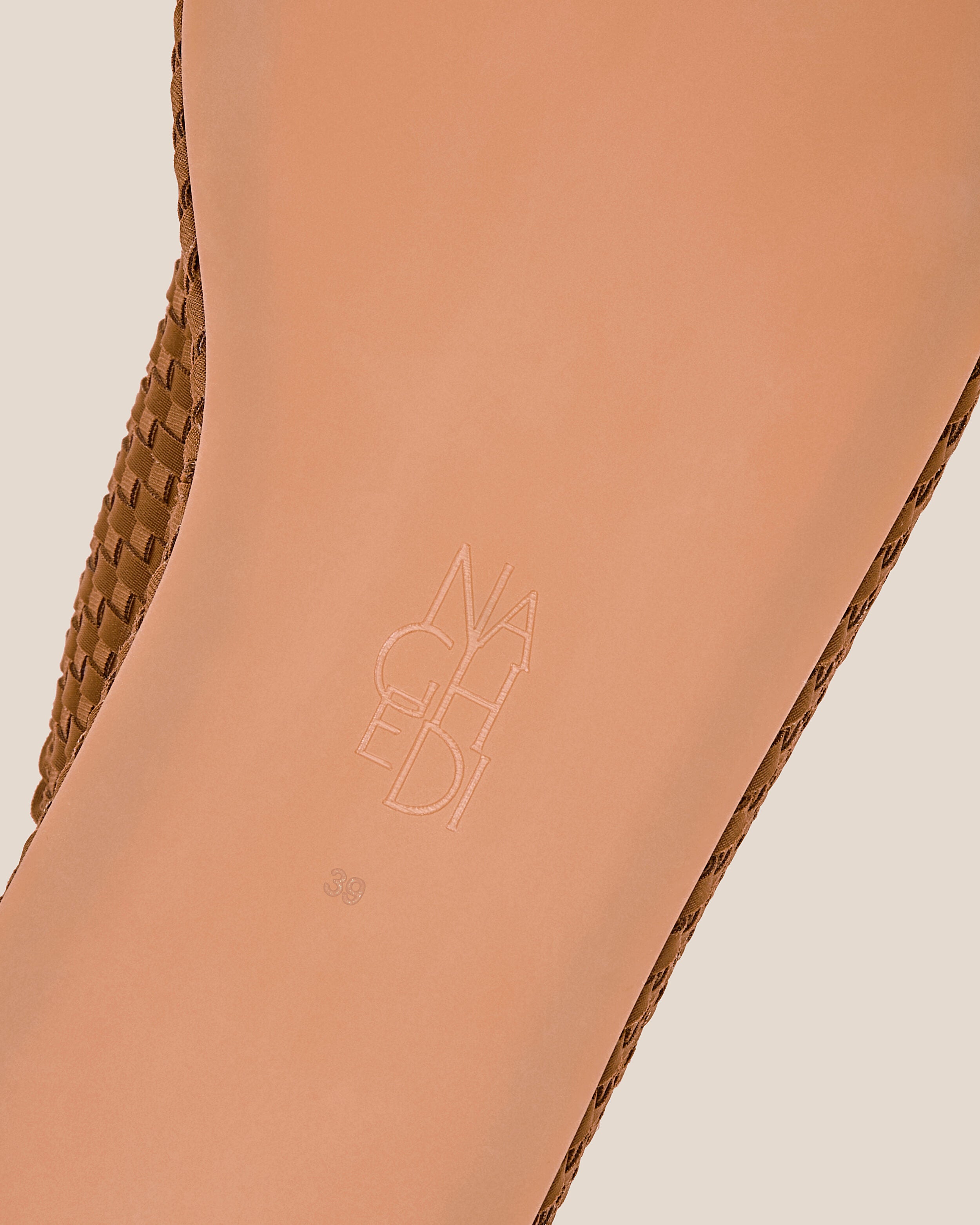 Shoe sole showing natural rubber sole, stamped NAGHEDI logo and size detail for The Laguna Platform in Teak.