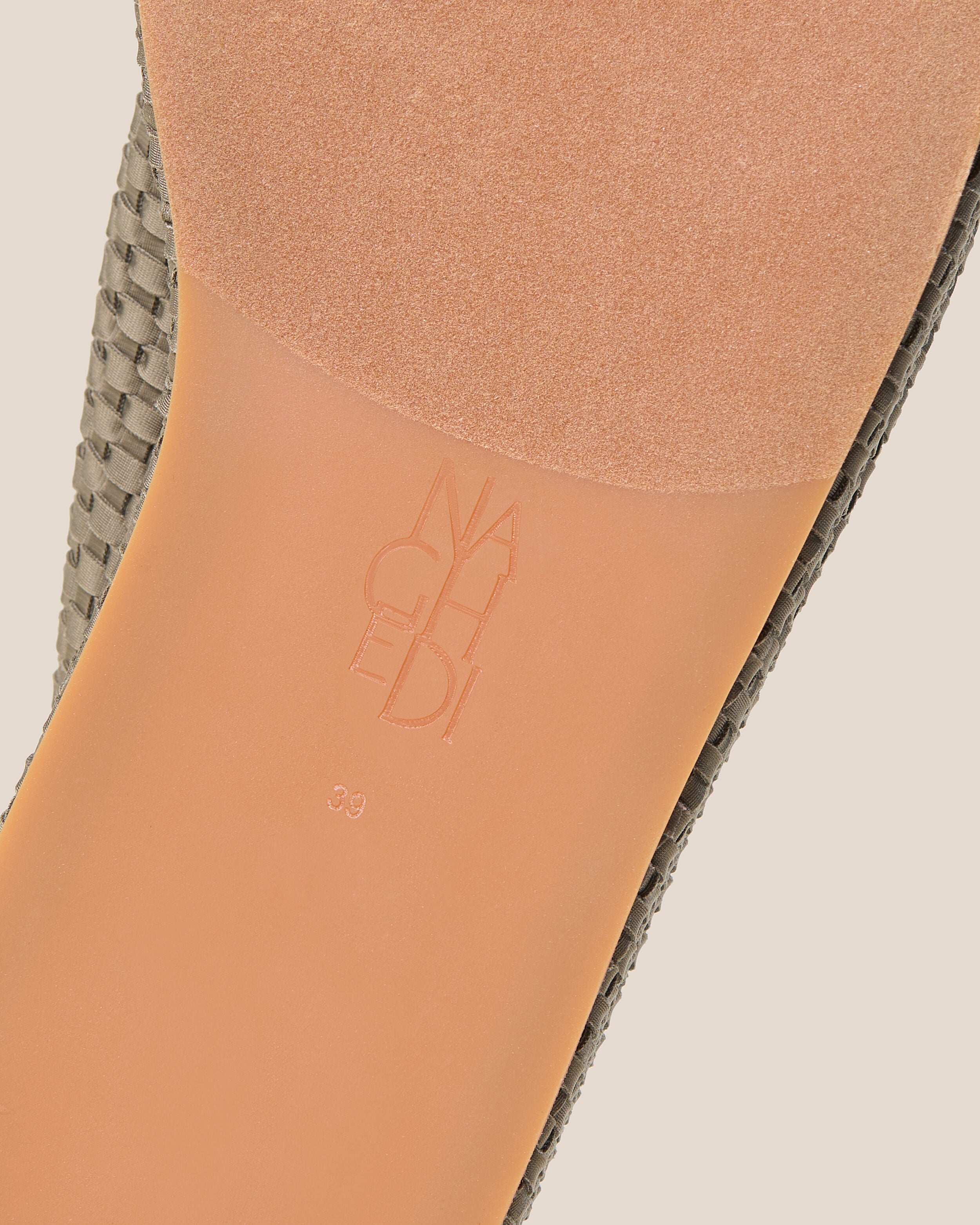 Shoe sole showing natural rubber sole, stamped NAGHEDI logo and size detail for The Laguna Platform in Terre.