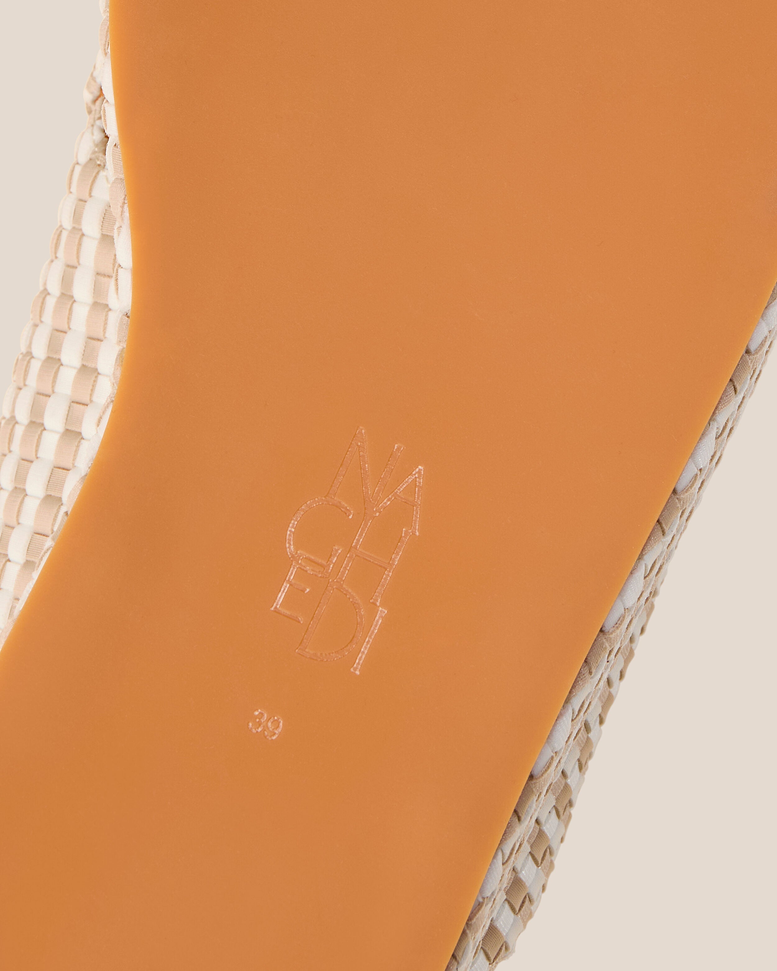 Shoe sole showing natural rubber sole, stamped NAGHEDI logo and size detail for The Laguna Platform in Mykonos.