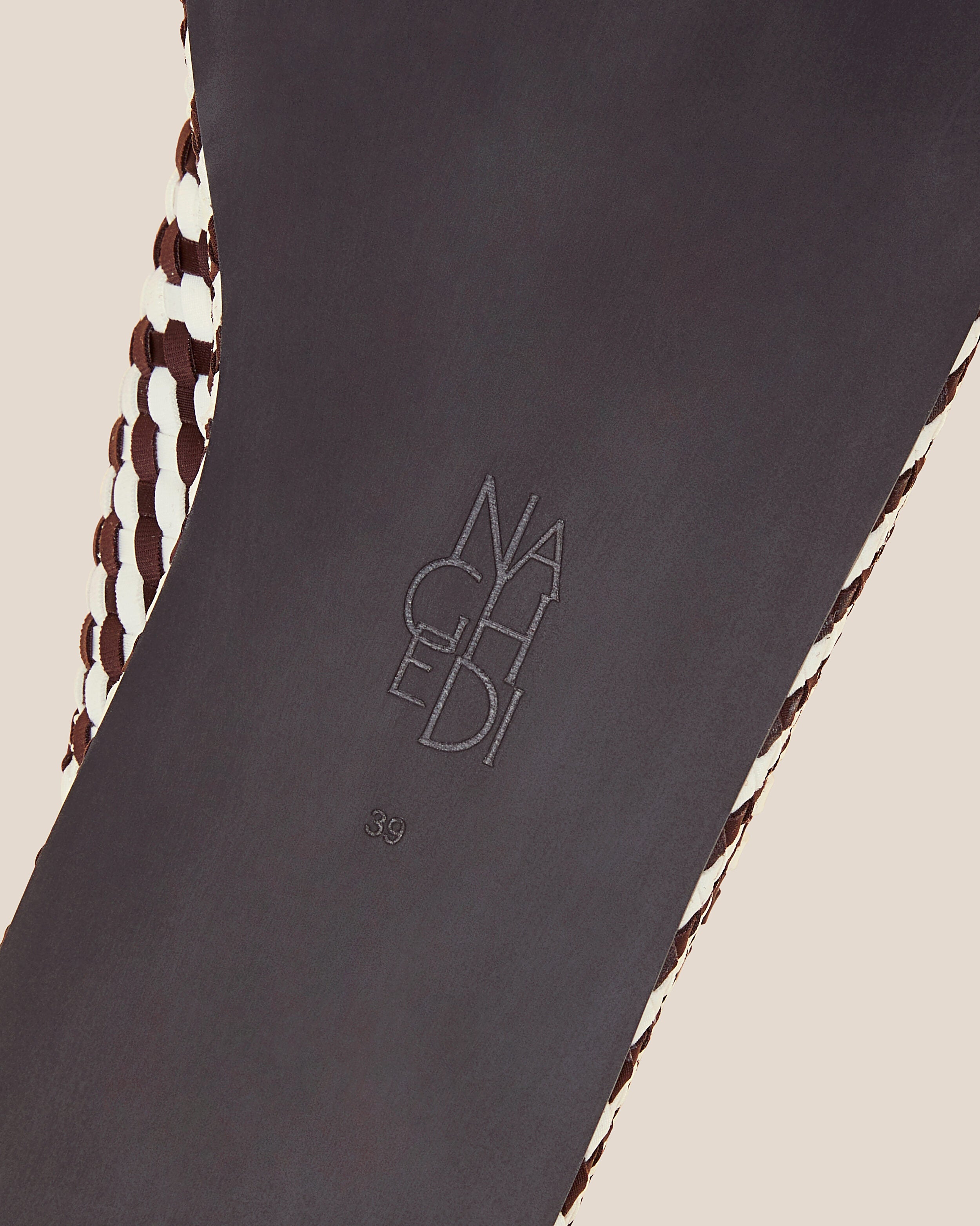 Shoe sole showing natural rubber sole, stamped NAGHEDI logo and size detail for The Laguna Platform in Roma.