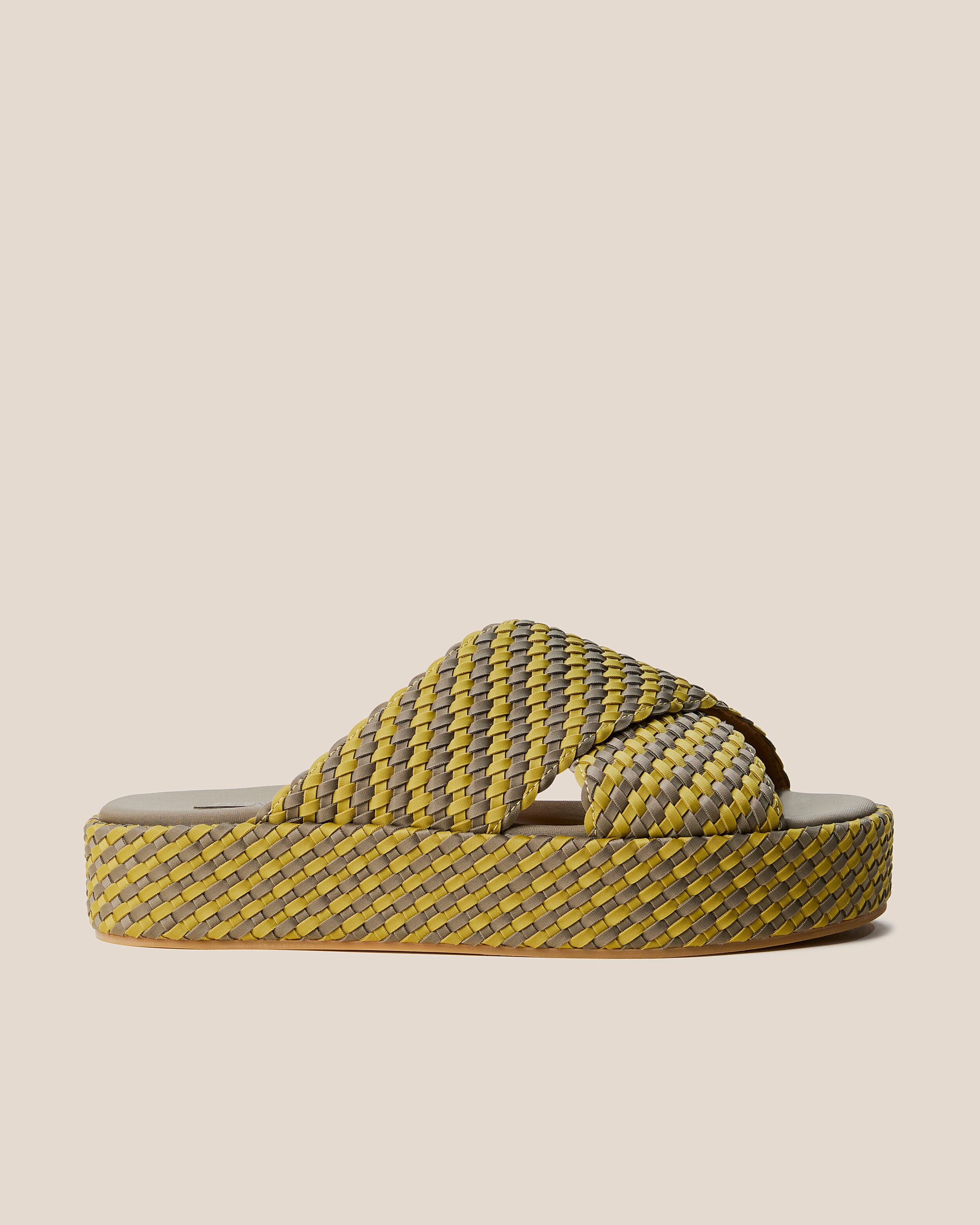 Side view of The Laguna Platform in Palma, a yellow-green and muted earh brown tone, featuring an open toe and round silhouette.