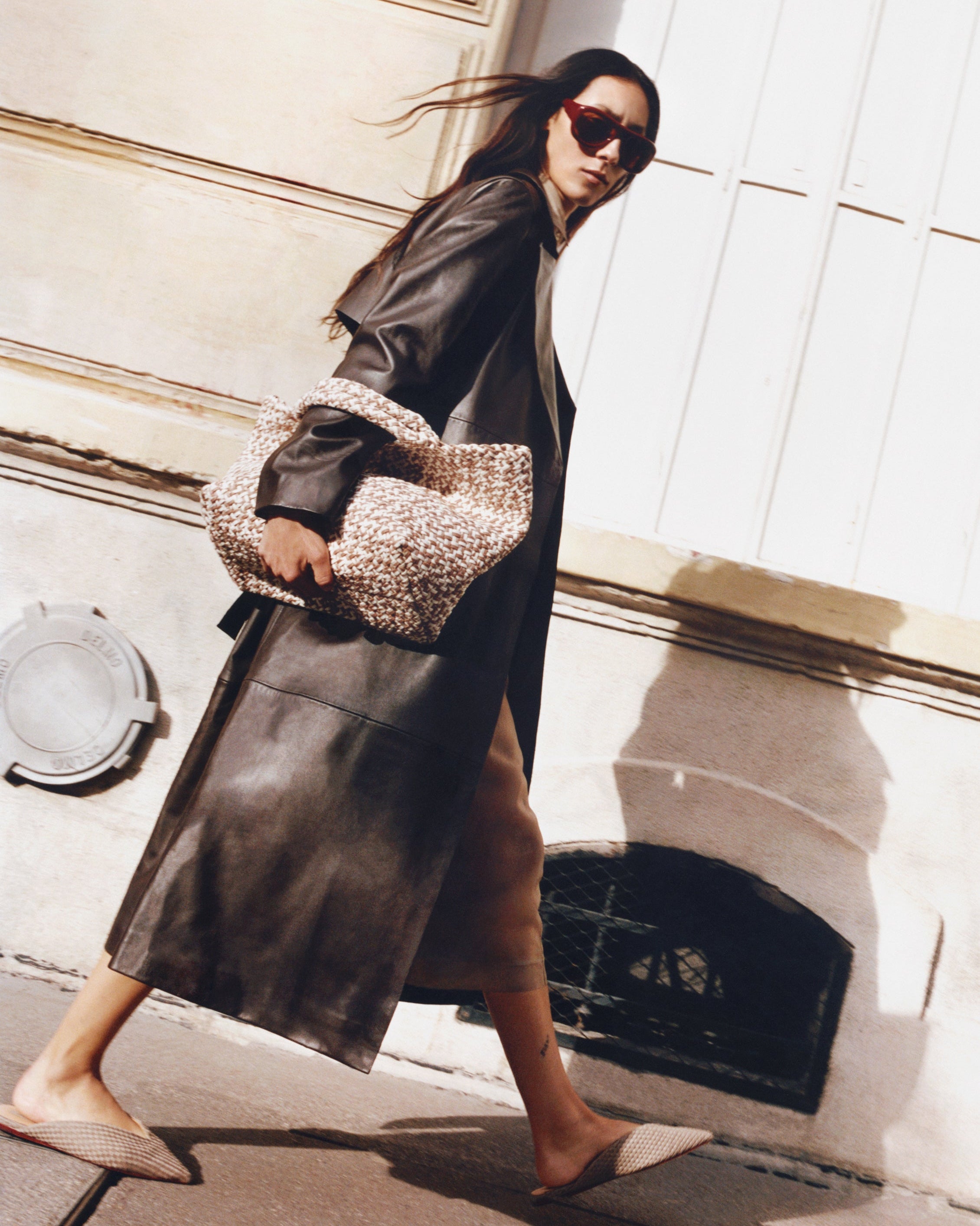 Full body on model image of the St. Barths Medium Tote in Flax. Highlighting the handwoven neoprene design and top handles.