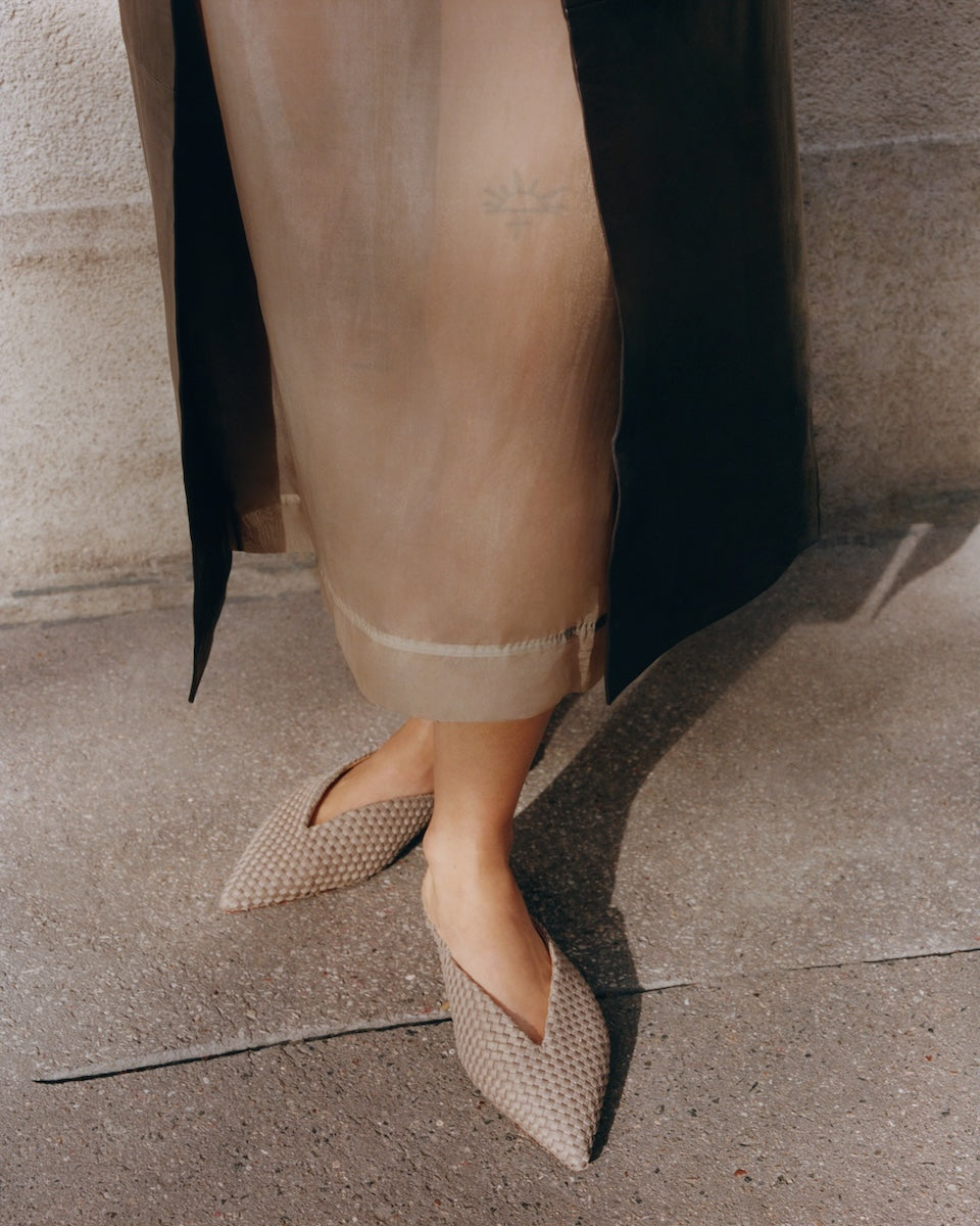 On model close-up of woven pointed-toe mule flats in Cashmere highlighting the pointed toe.