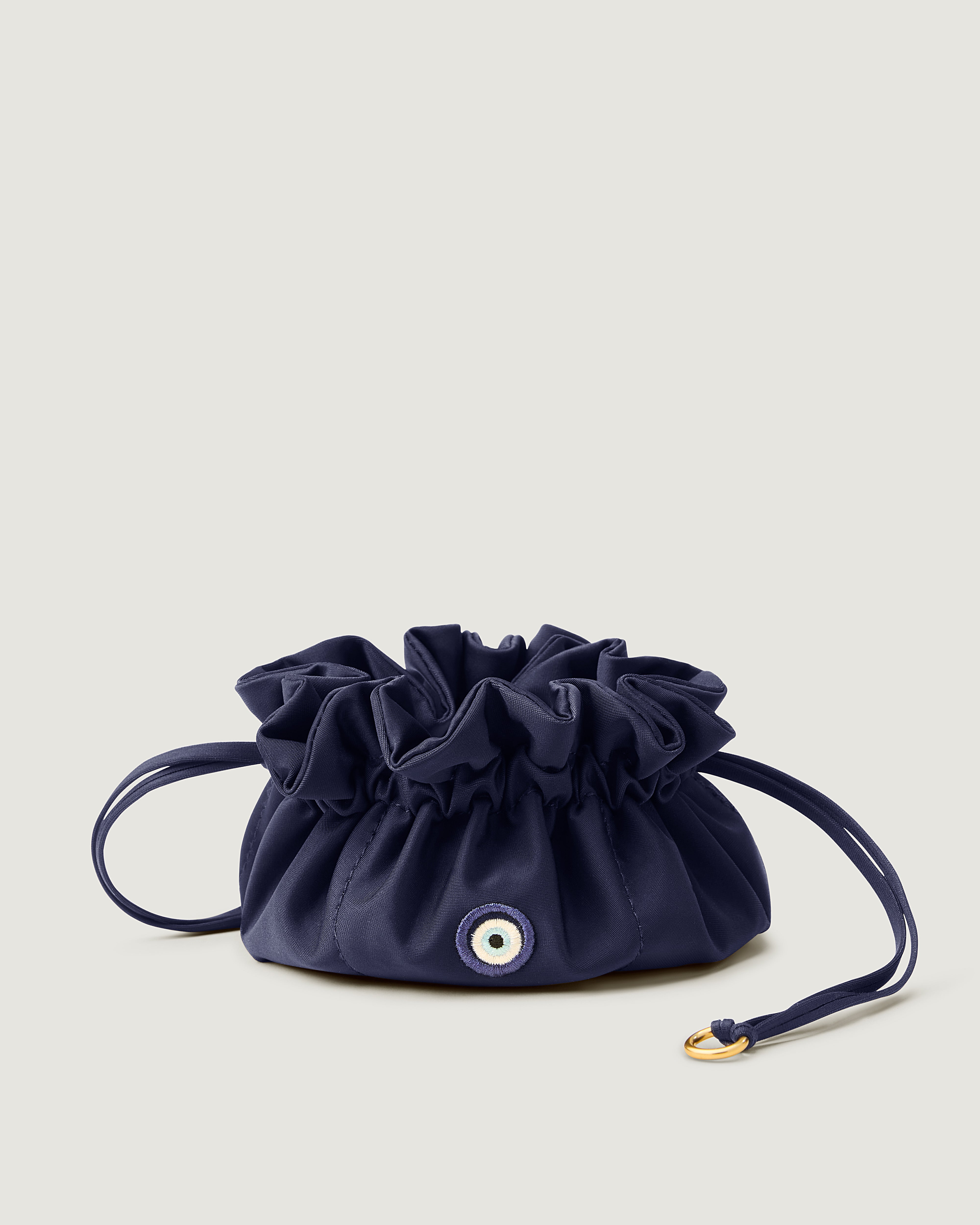 Lotus Jewelry Pouch in Ink Blue featuring a drawstring closure and Evil Eye embroidery.