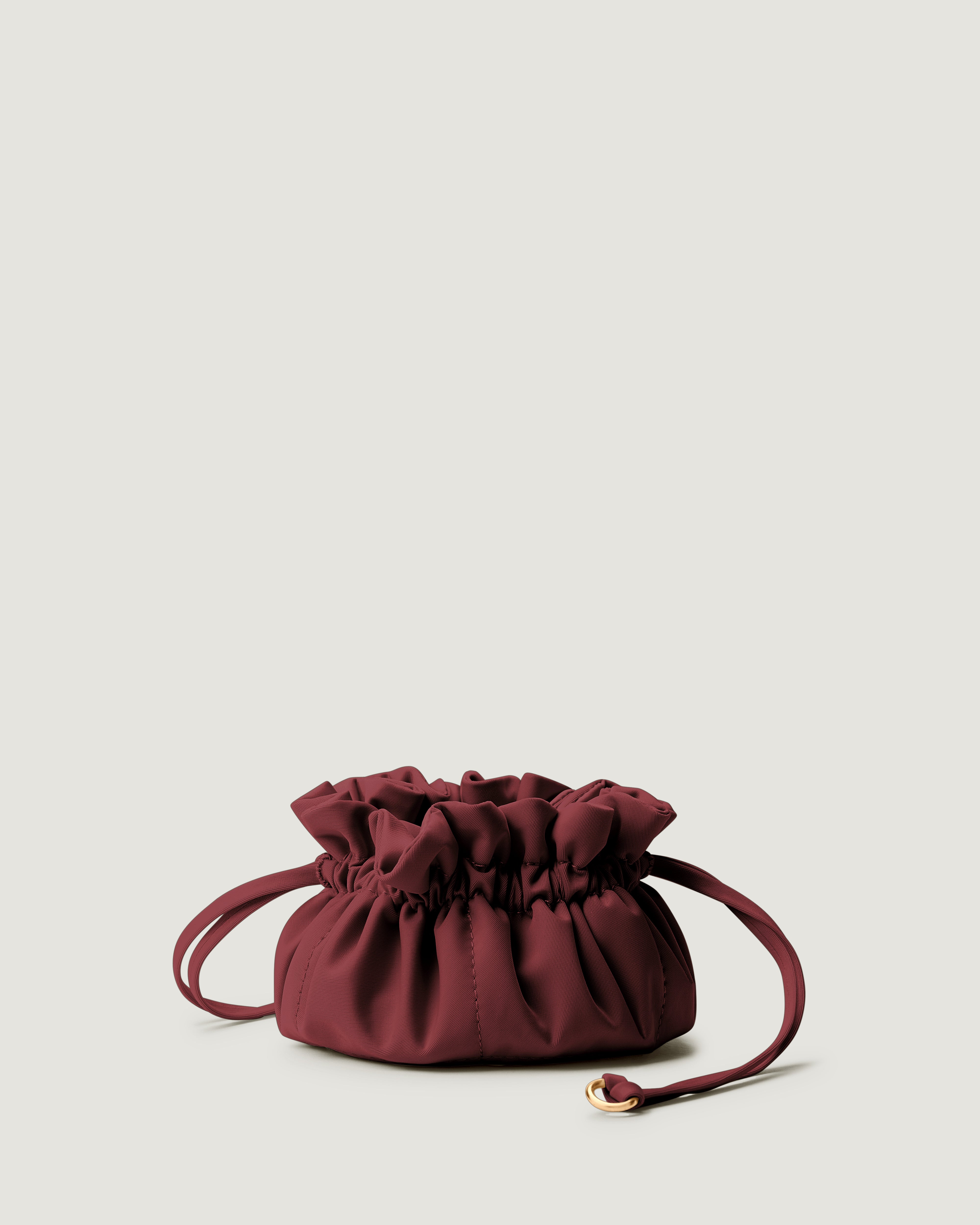 A small burgundy neoprene drawstring jewelry pouch.