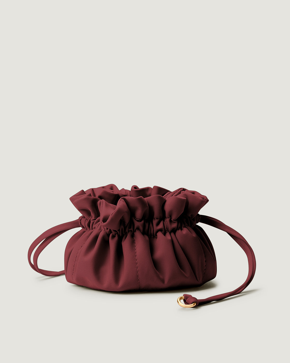 A small burgundy neoprene drawstring jewelry pouch.