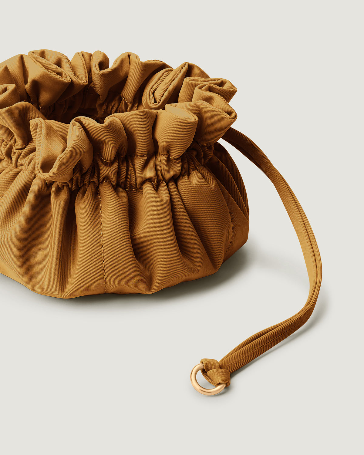 A close-up image of a small golden chartreuse neoprene drawstring jewelry pouch.
