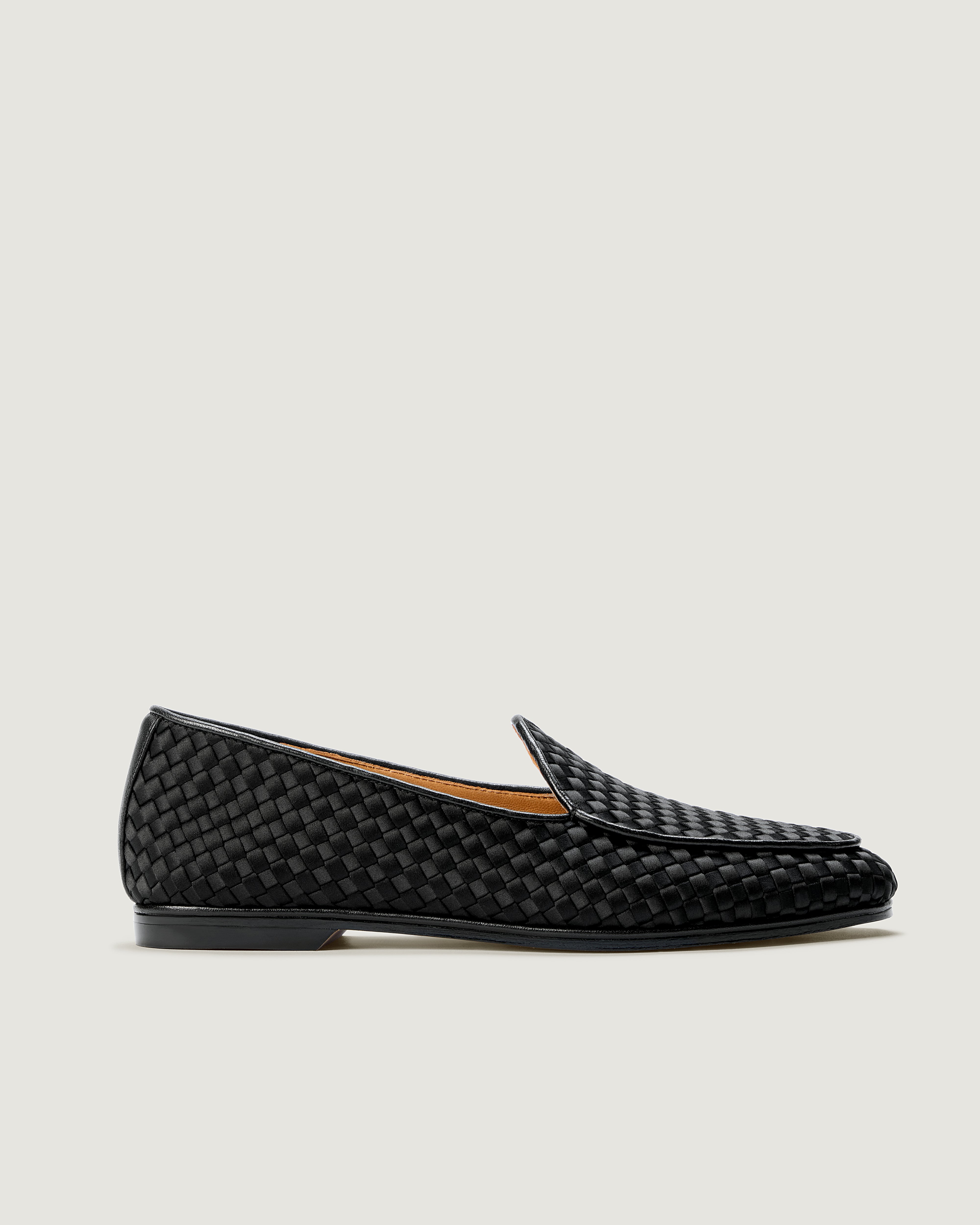 A single black handwoven satin loafer with leather trim shown in a side profile.