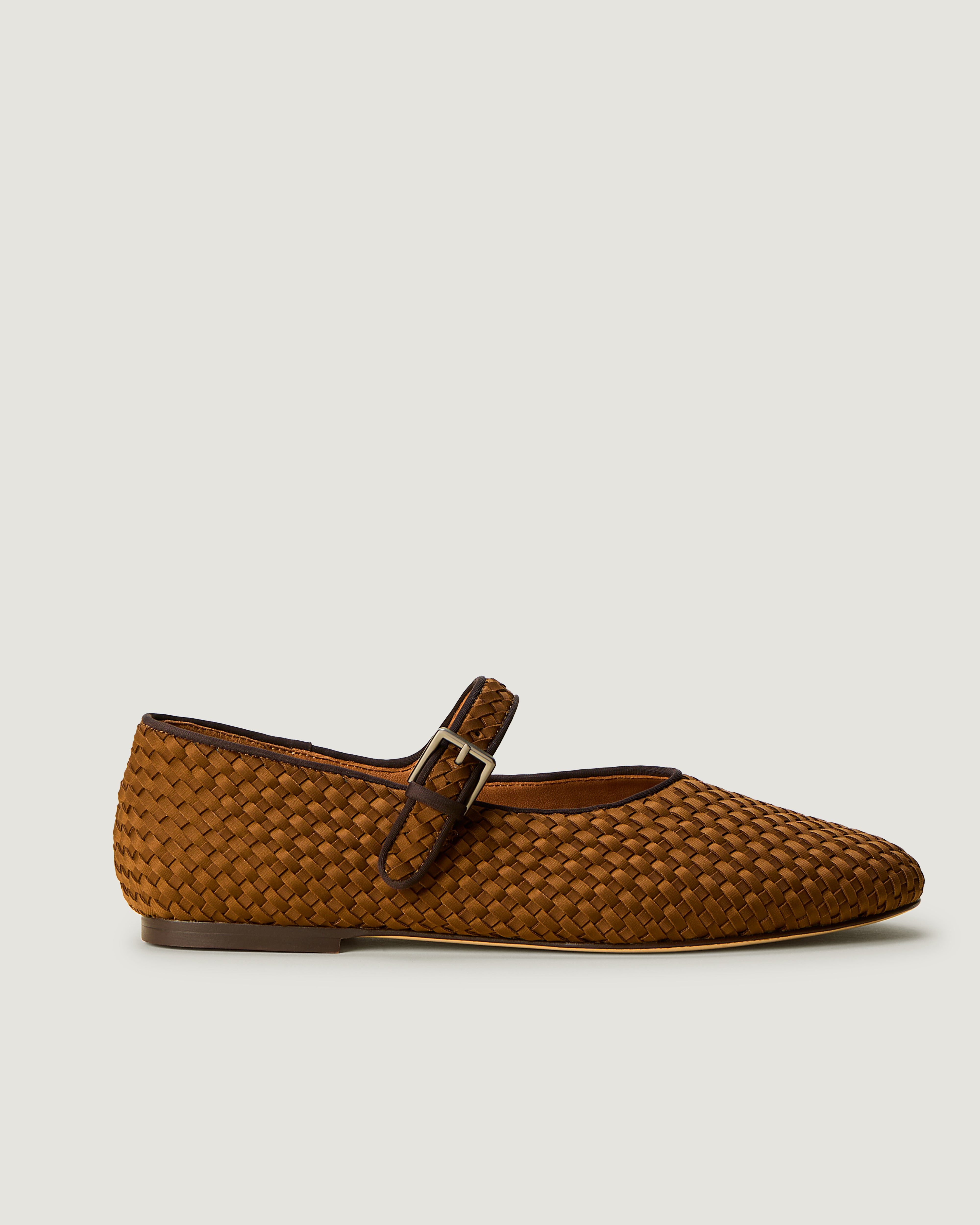 Side view of The Marais Mary Jane in Teak, a saddle brown tone, featuring a closed toe and round silhouette, featuring an adjustable strap with buckle closure.