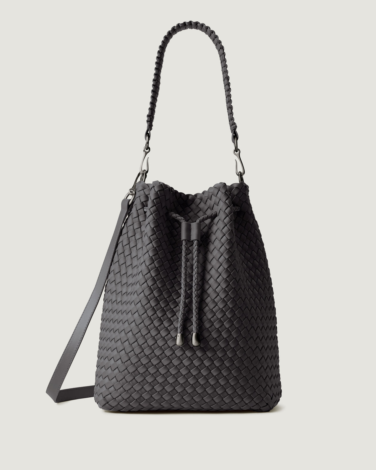 Mercer Bucket in Ash, a true gray tone, in handwoven neoprene, featuring a drawstring closure, and removable, adjustable leather crossbody strap.