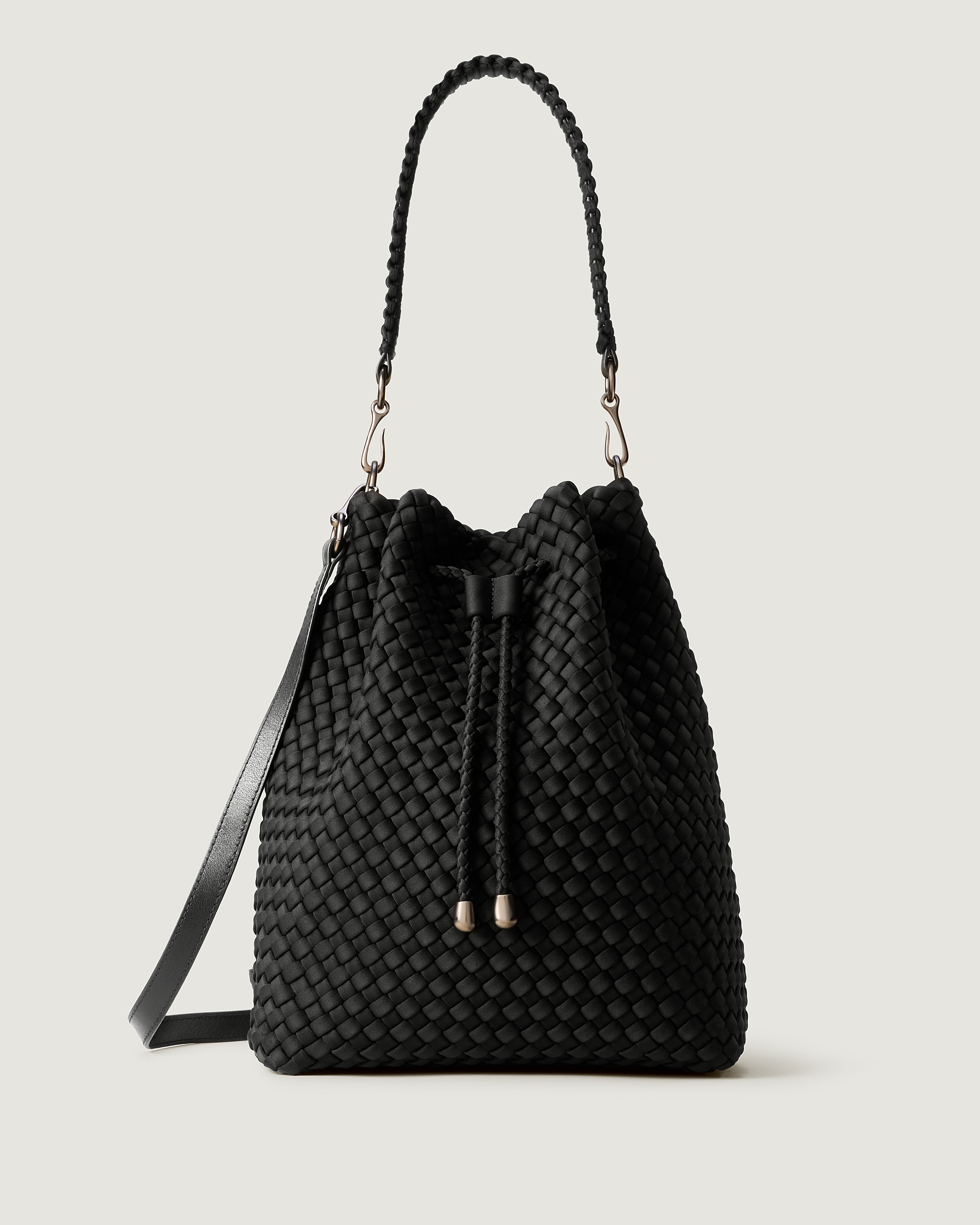 Mercer Bucket in Onyx, a true black tone, in handwoven neoprene, featuring a drawstring closure, and removable, adjustable leather crossbody strap.